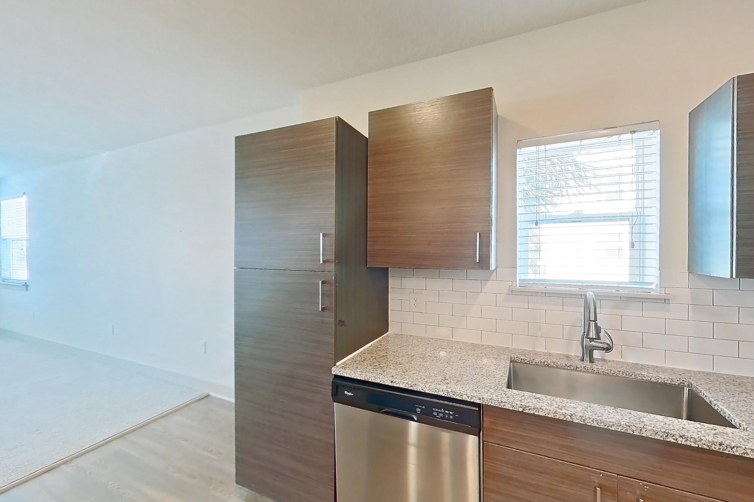 Kitchen with dishwasher, electric range, light stone countertops, light wood-finish flooring, microwave, oven/range, refrigerator, and stainless steel appliances, Apartment 148-201 at Domain