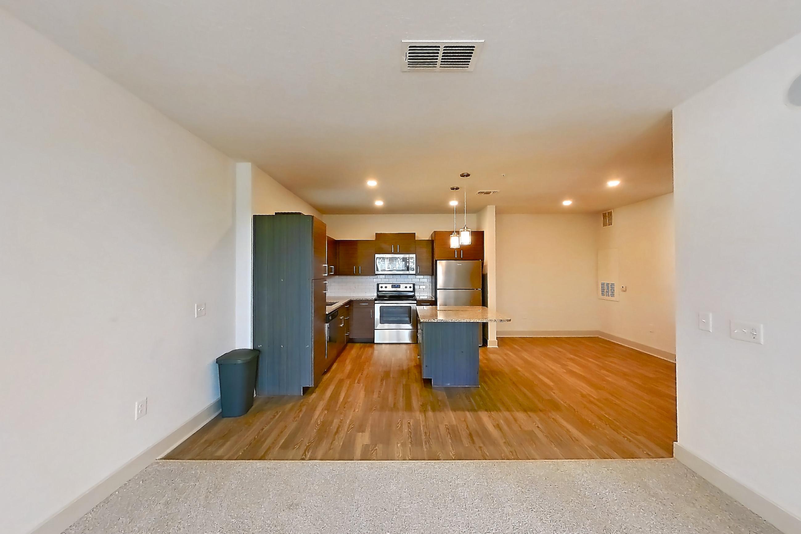 Living room with dishwasher, electric range, light stone countertops, oven/range, refrigerator, and stainless steel appliances, Apartment 148-201 at Domain
