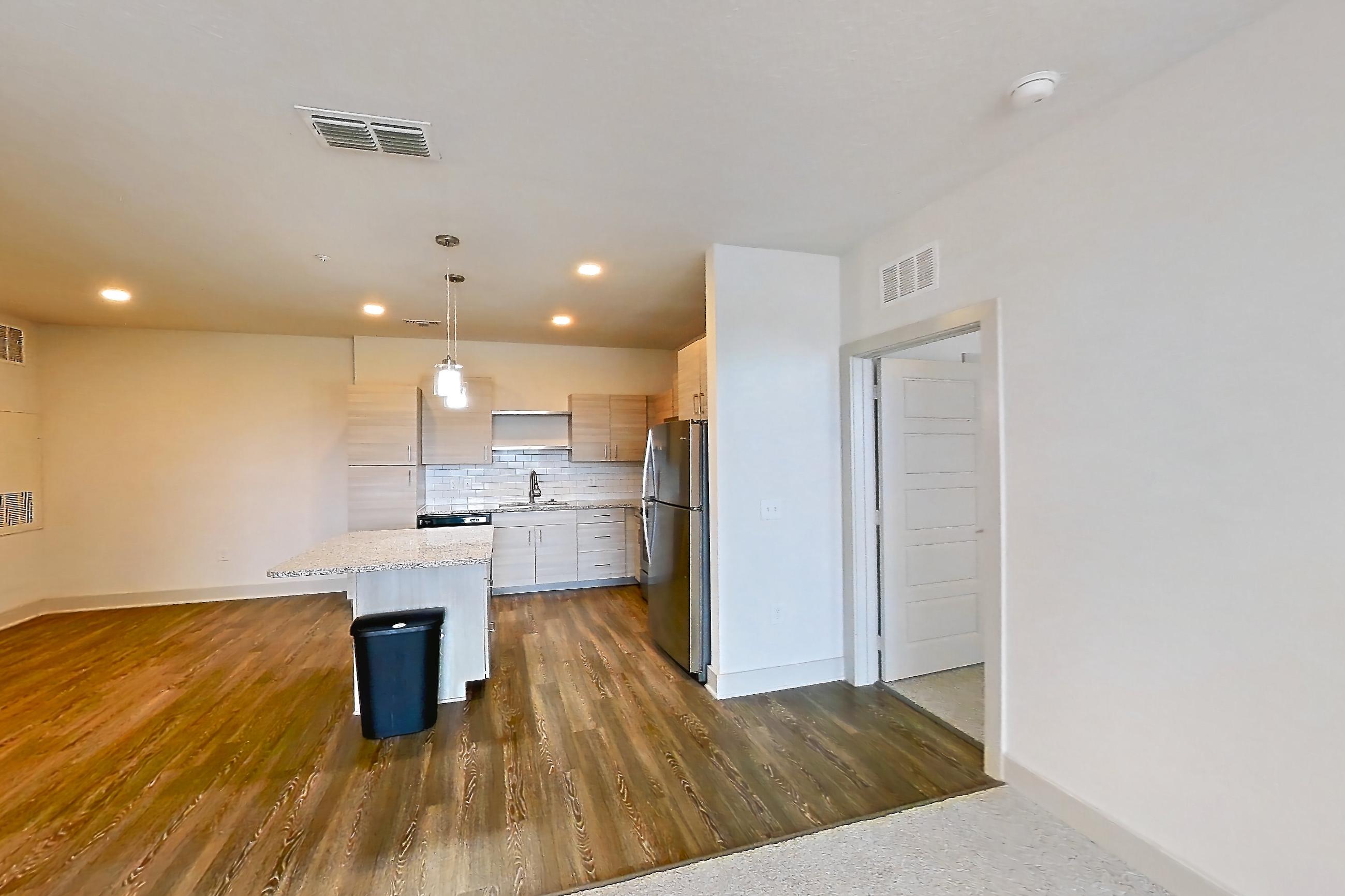 Living room with cooktop, light carpet, refrigerator, stainless steel appliances, and white appliances, Apartment 144-202 at Domain