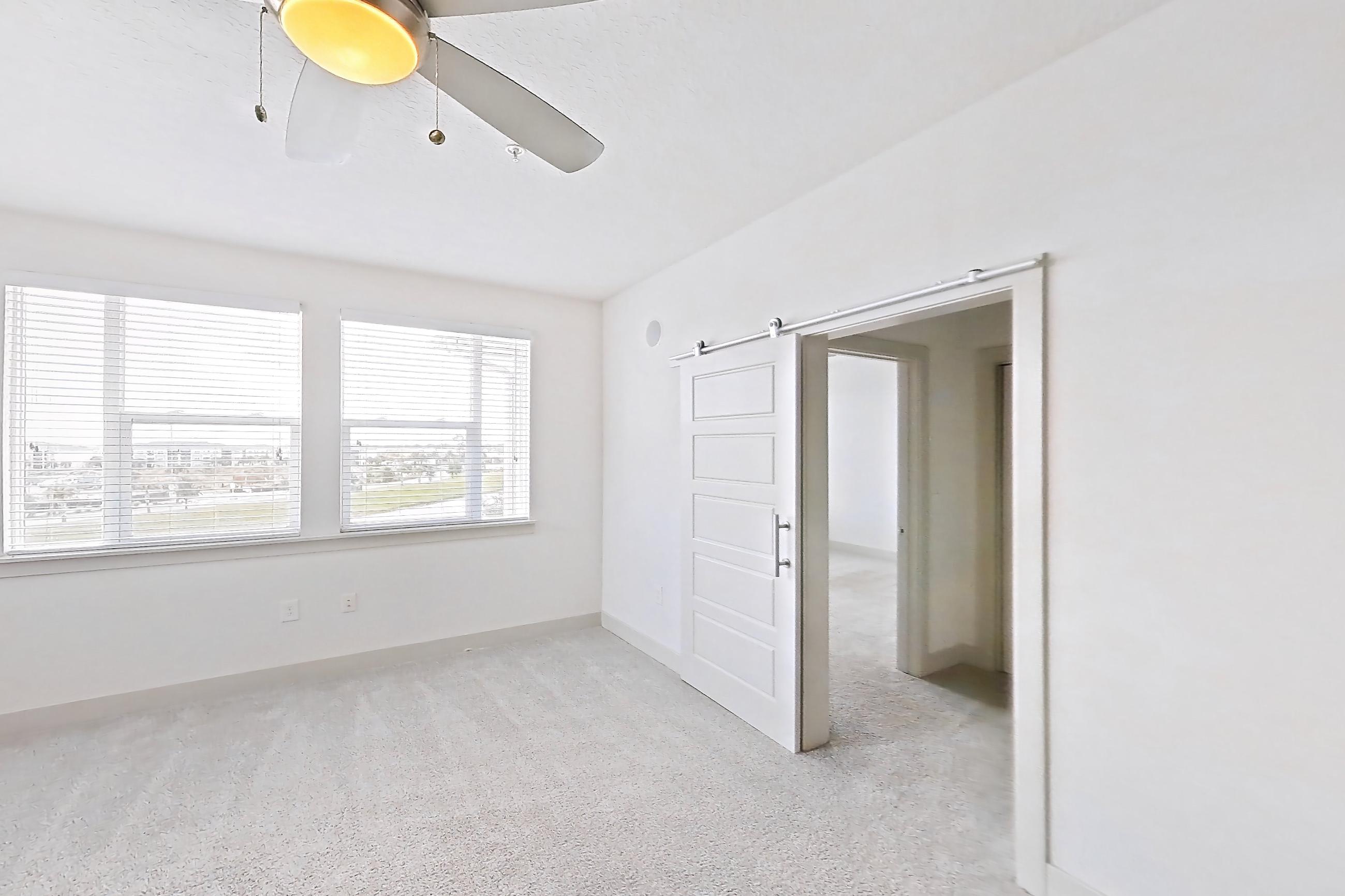 Living room with black appliances, dark wood-finish flooring, dishwasher, and light stone countertops, Apartment 148-302 at Domain