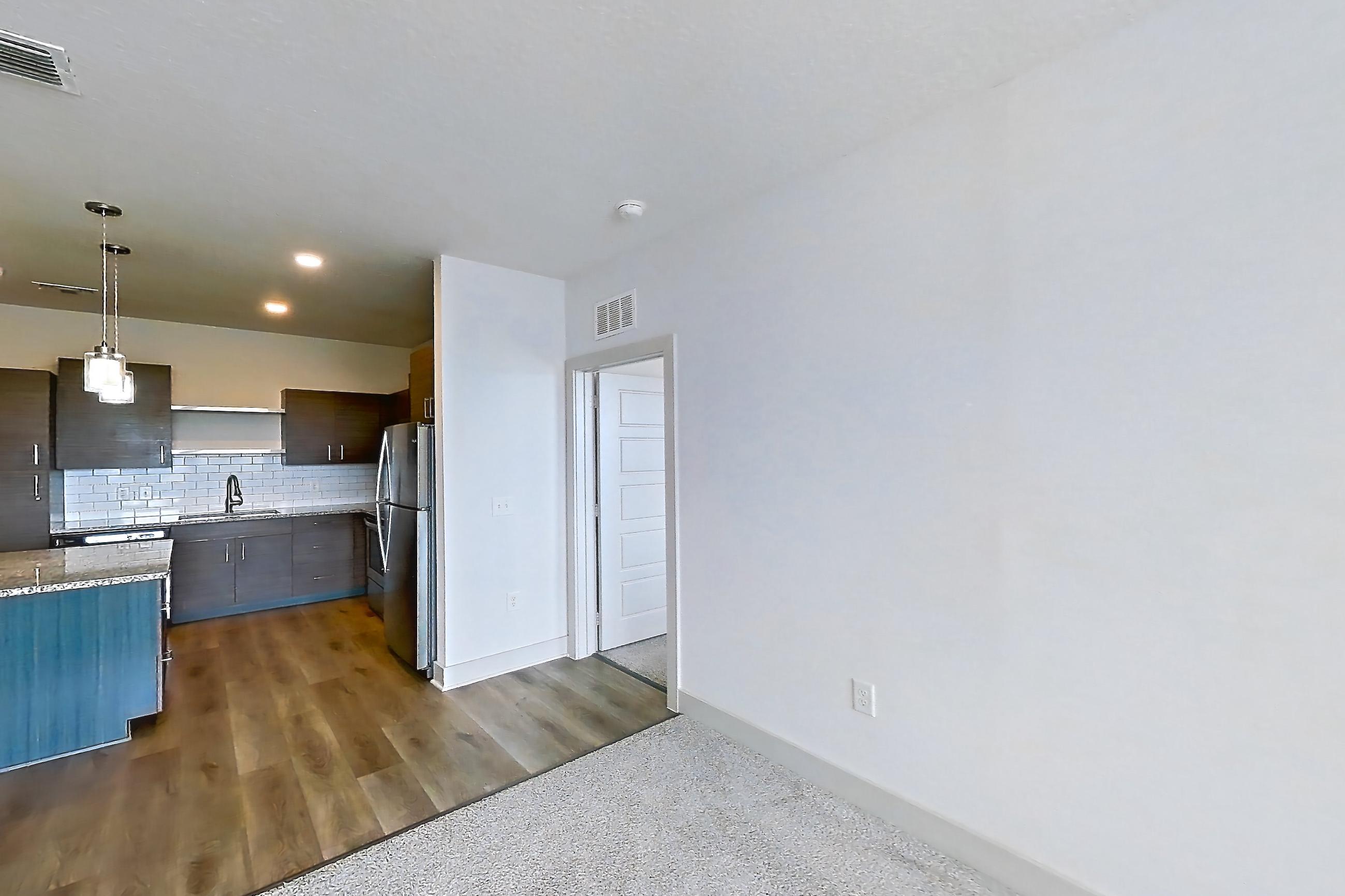 Living room with light carpet, refrigerator, and stainless steel appliances, Apartment 156-202 at Domain