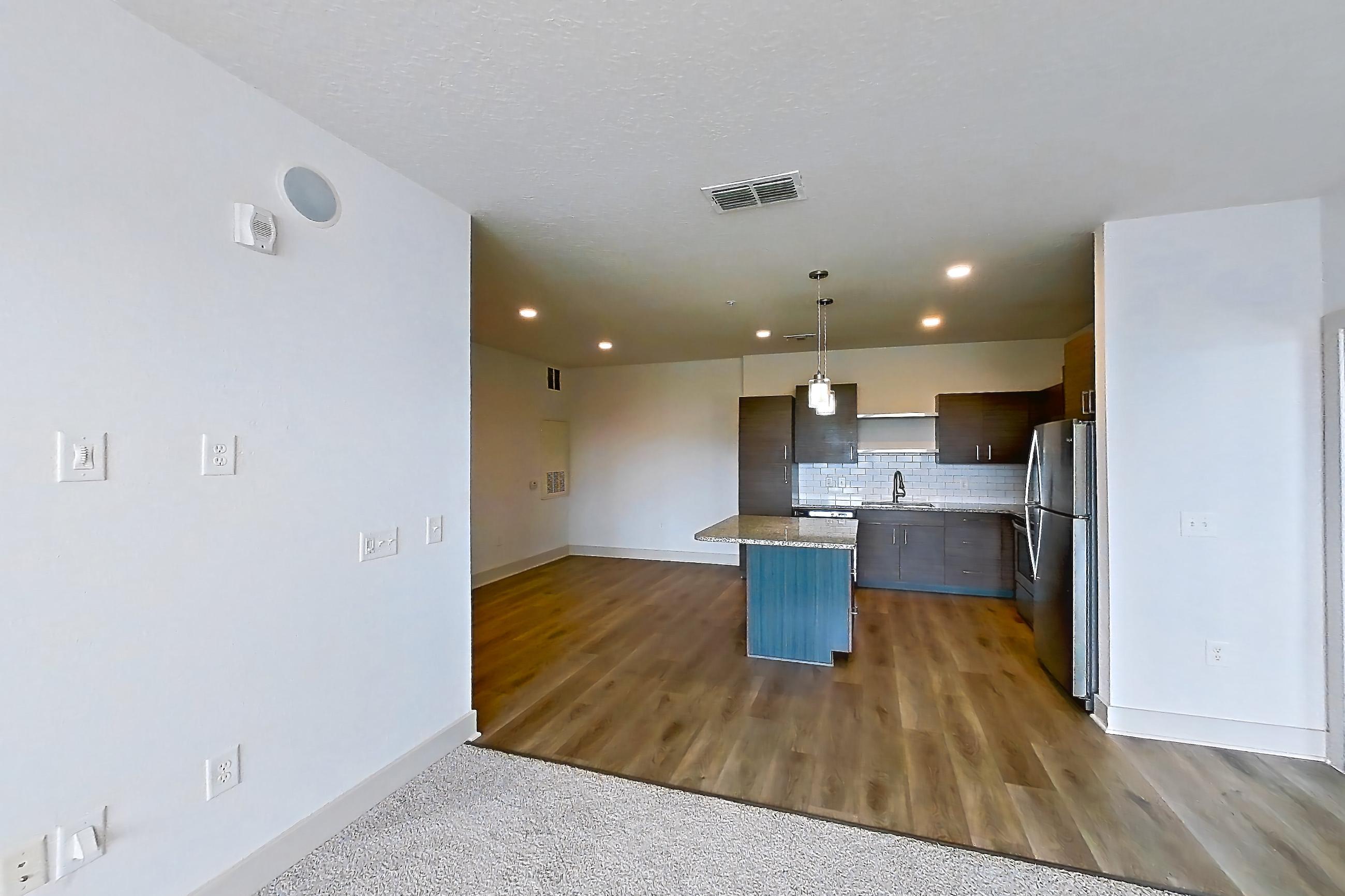 Living room with light carpet, refrigerator, and stainless steel appliances, Apartment 156-202 at Domain