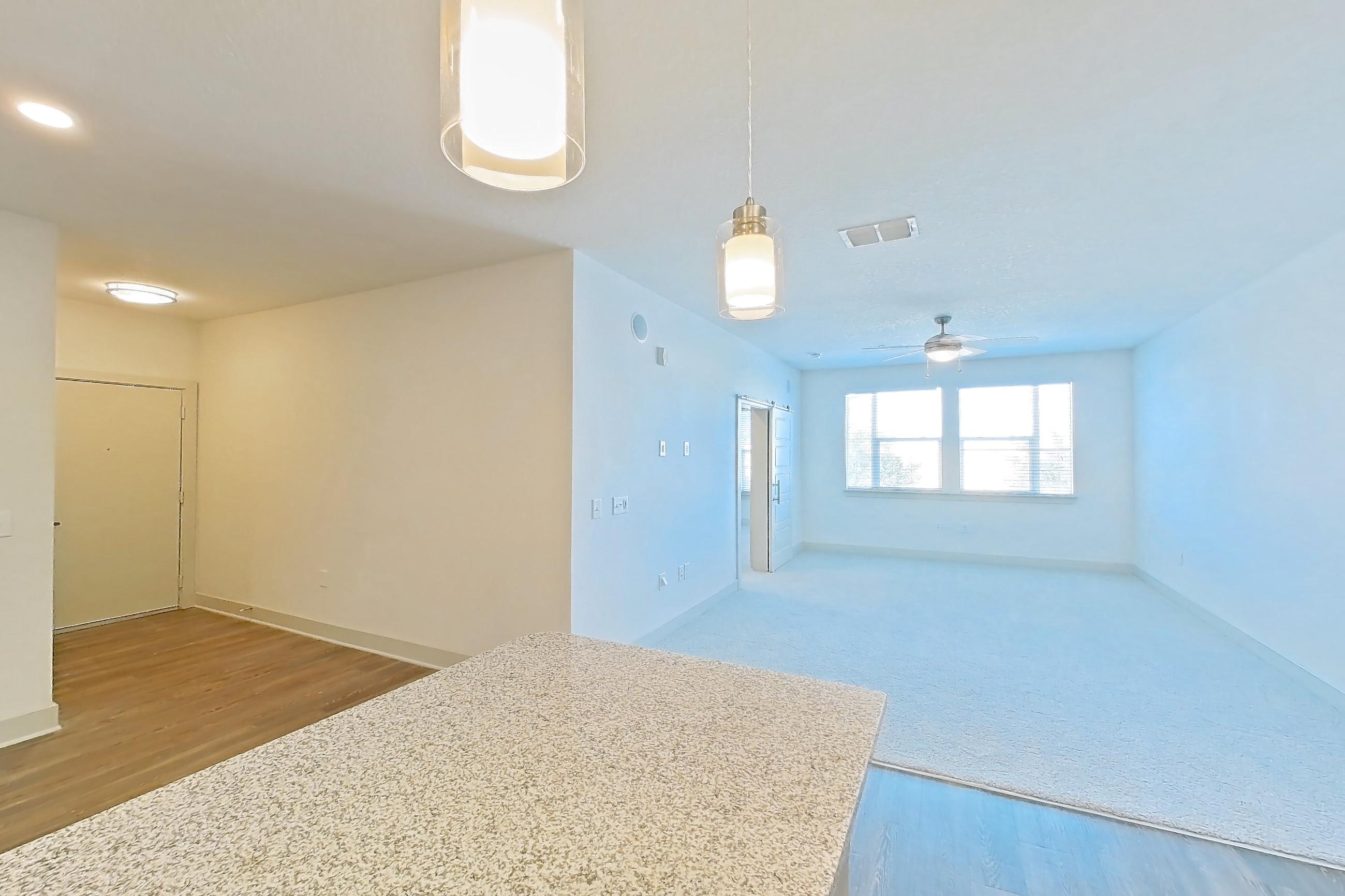 Kitchen with dishwasher, electric range, light countertops, light stone countertops, light wood-finish flooring, oven/range, refrigerator, and stainless steel appliances, Apartment 114-301 at Domain