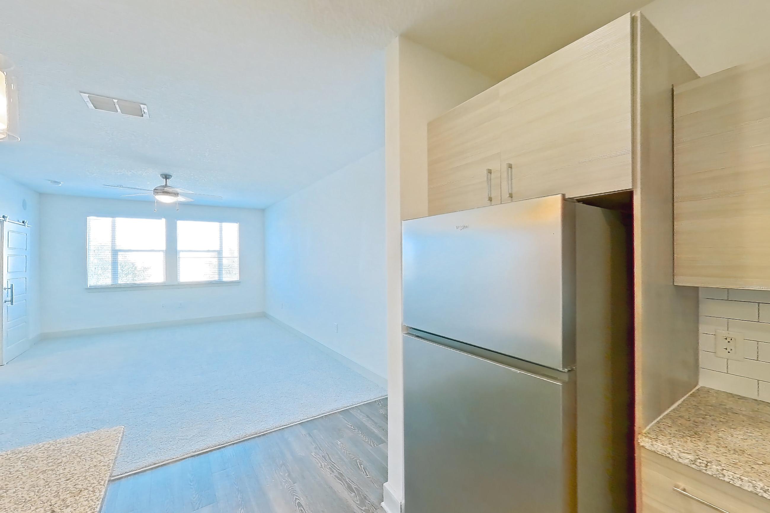 Kitchen with dishwasher, electric range, light countertops, light stone countertops, light wood-finish flooring, oven/range, refrigerator, and stainless steel appliances, Apartment 114-301 at Domain