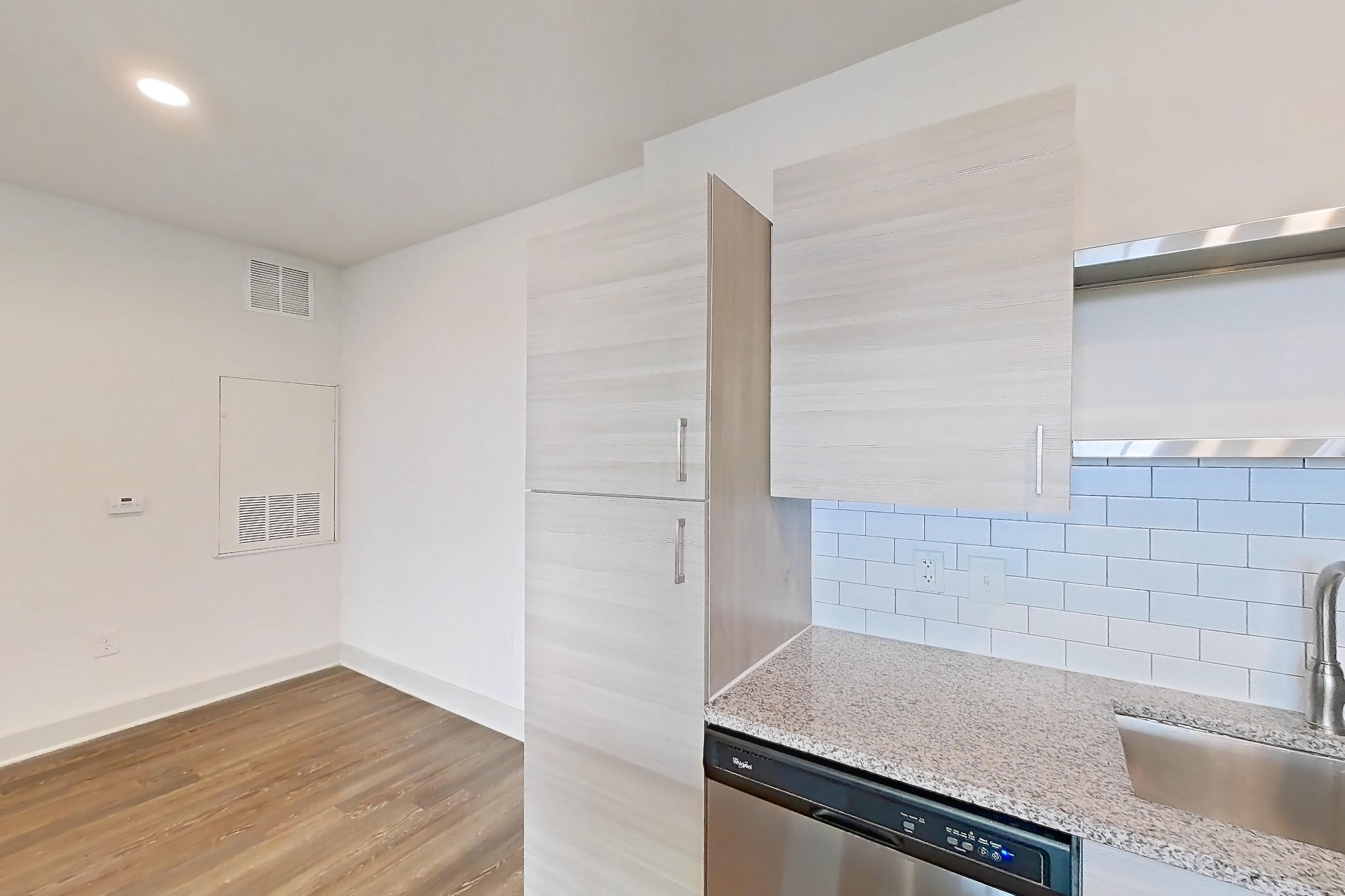 Kitchen with dishwasher, electric range, light countertops, light stone countertops, light wood-finish flooring, oven/range, refrigerator, and stainless steel appliances, Apartment 116-302 at Domain