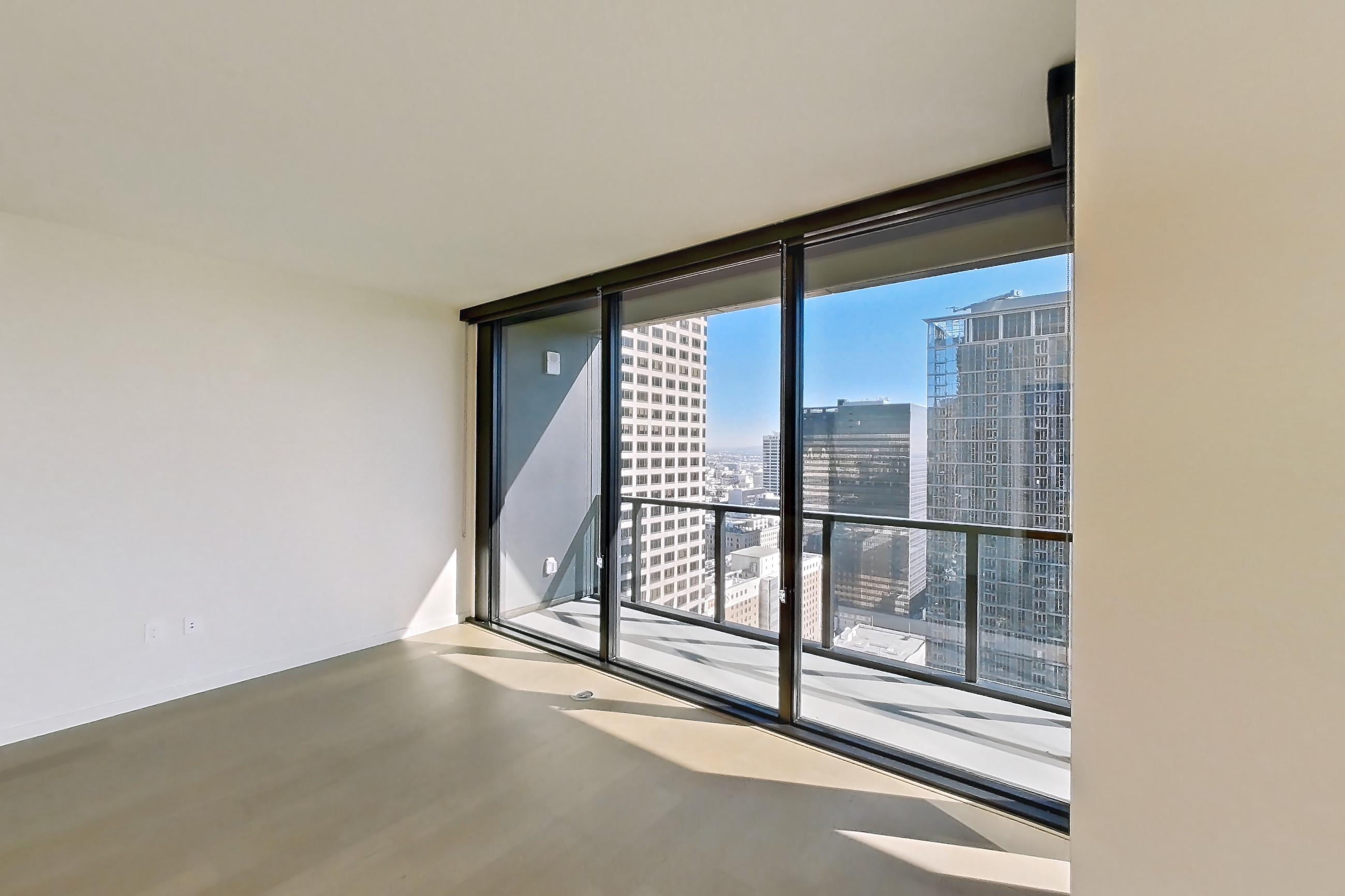 Living room with city view and light wood-finish flooring, Apartment B-3216 at Beaudry