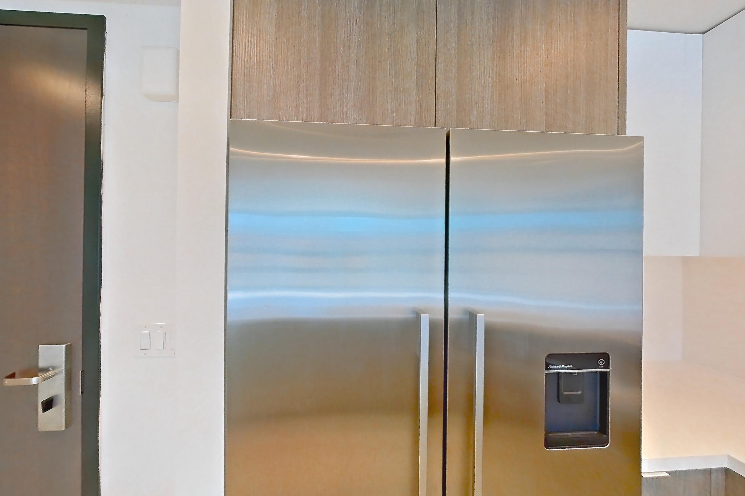 Kitchen with electric range, light countertops, light wood-finish flooring, oven/range, refrigerator, stainless steel appliances, and water & ice dispenser, Apartment 0609 at Atelier