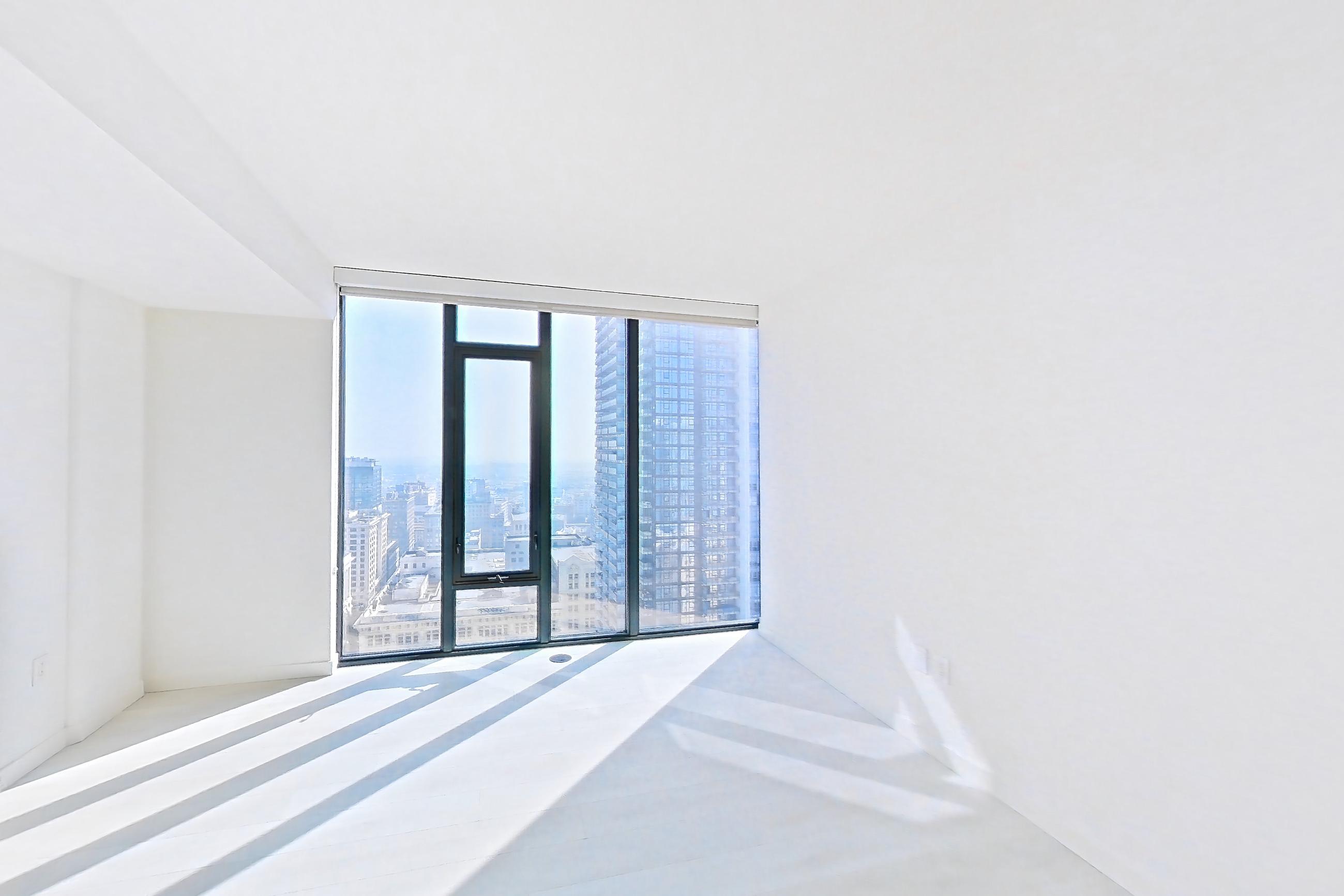 Living room with city view, electric cooktop, light stone countertops, and light wood-finish flooring, Apartment 2807 at Atelier