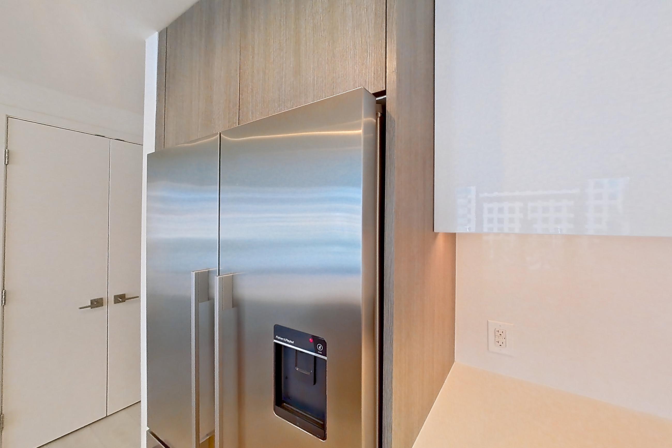 Kitchen with electric range, light countertops, oven/range, refrigerator, stainless steel appliances, and water & ice dispenser, Apartment 0608 at Atelier