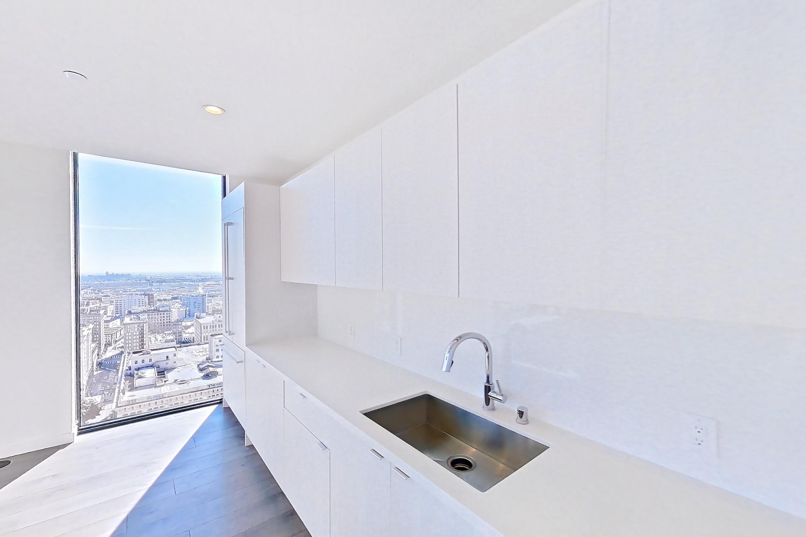Kitchen with cooktop, dark wood-finish flooring, gas cooktop, light stone countertops, oven/range, stainless steel appliances, and wood-finish flooring, Apartment 3001 at Atelier