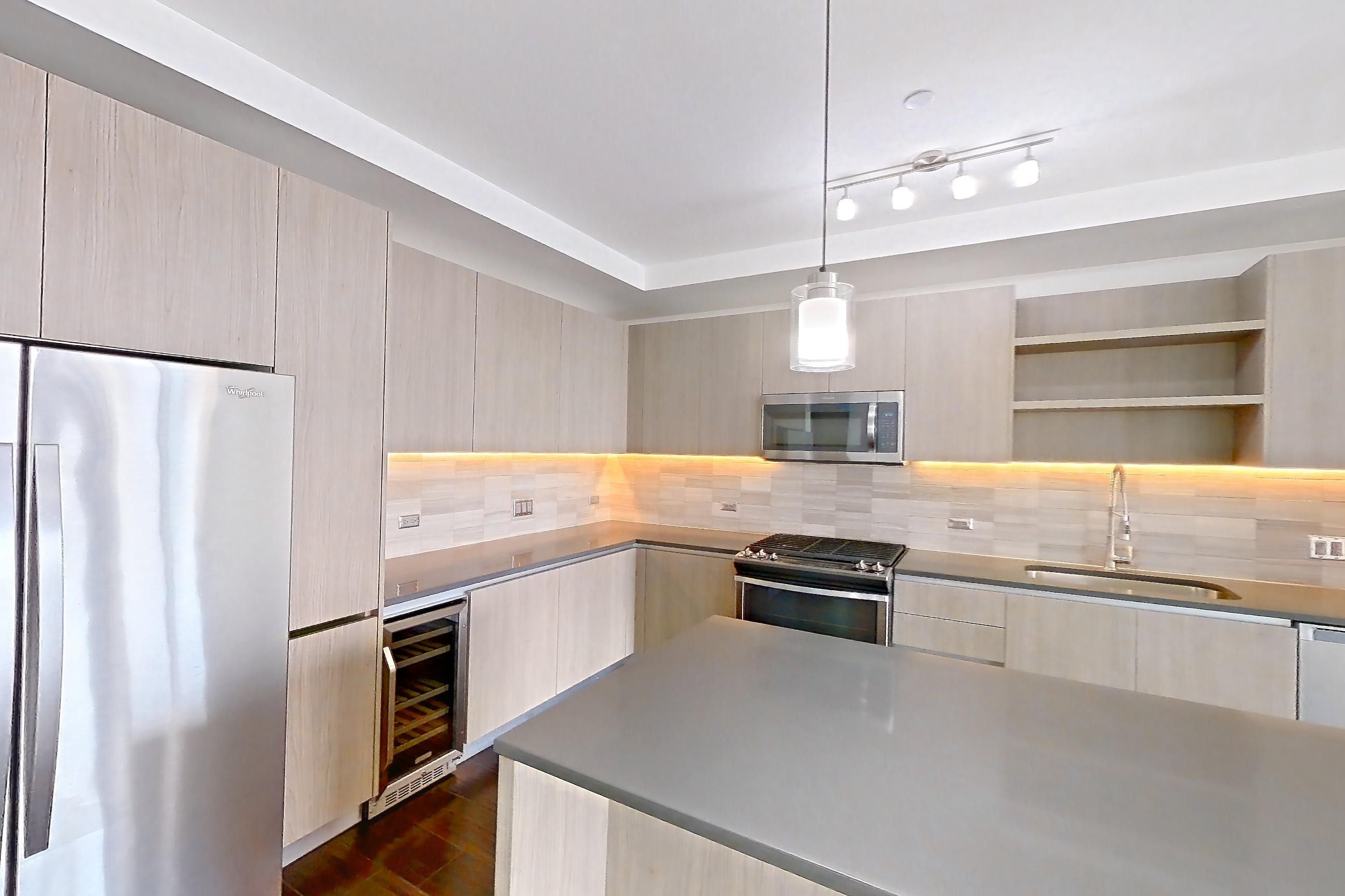 Kitchen space with dark countertops, dark wood-finish flooring, gas range, oven/range, stainless steel appliances, and wood-finish flooring, Apartment 1801 at Cortland Museum District