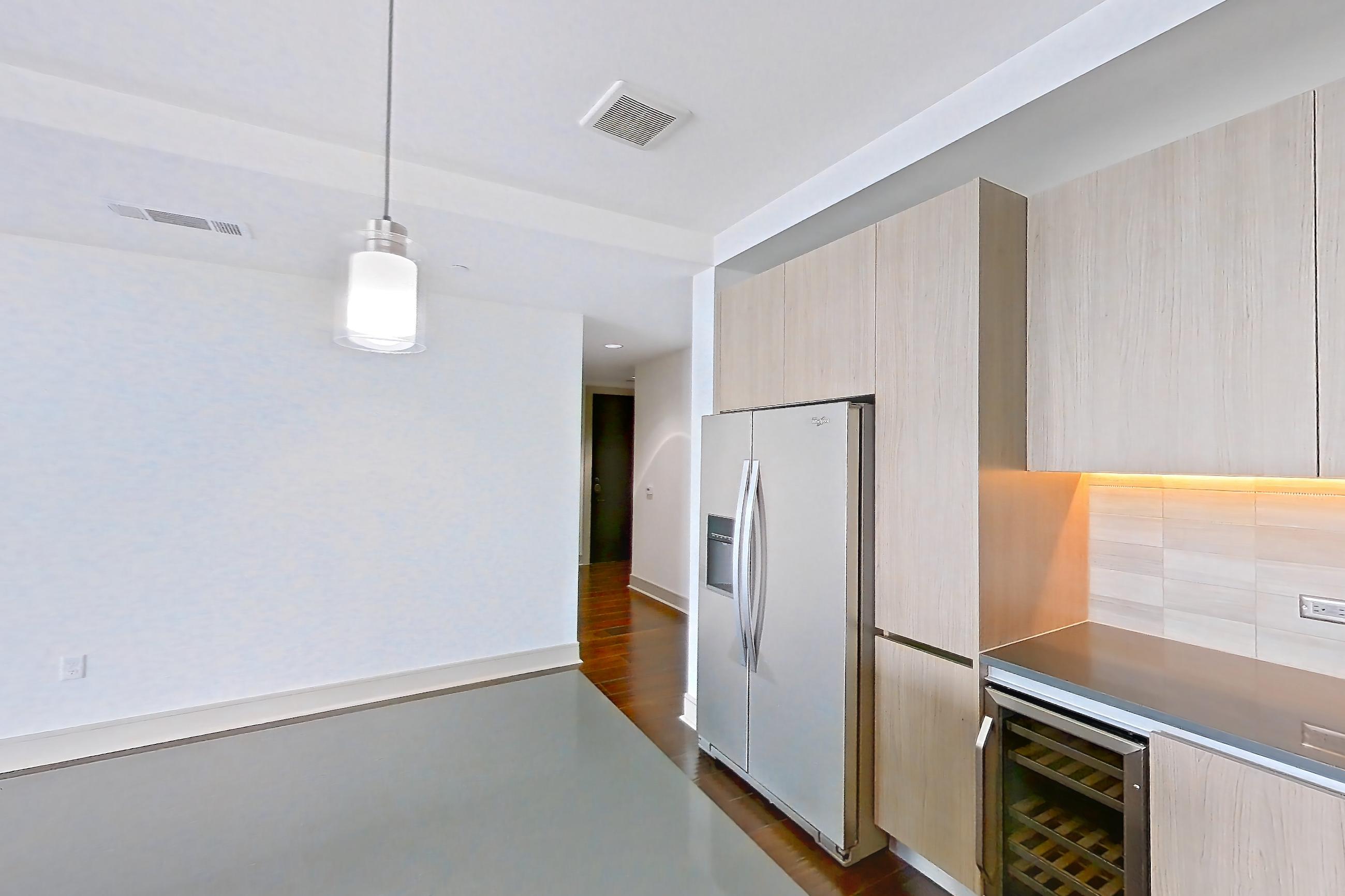 Kitchen with dark wood-finish flooring, gas range, oven/range, refrigerator, stainless steel appliances, and water & ice dispenser, Apartment 1801 at Cortland Museum District