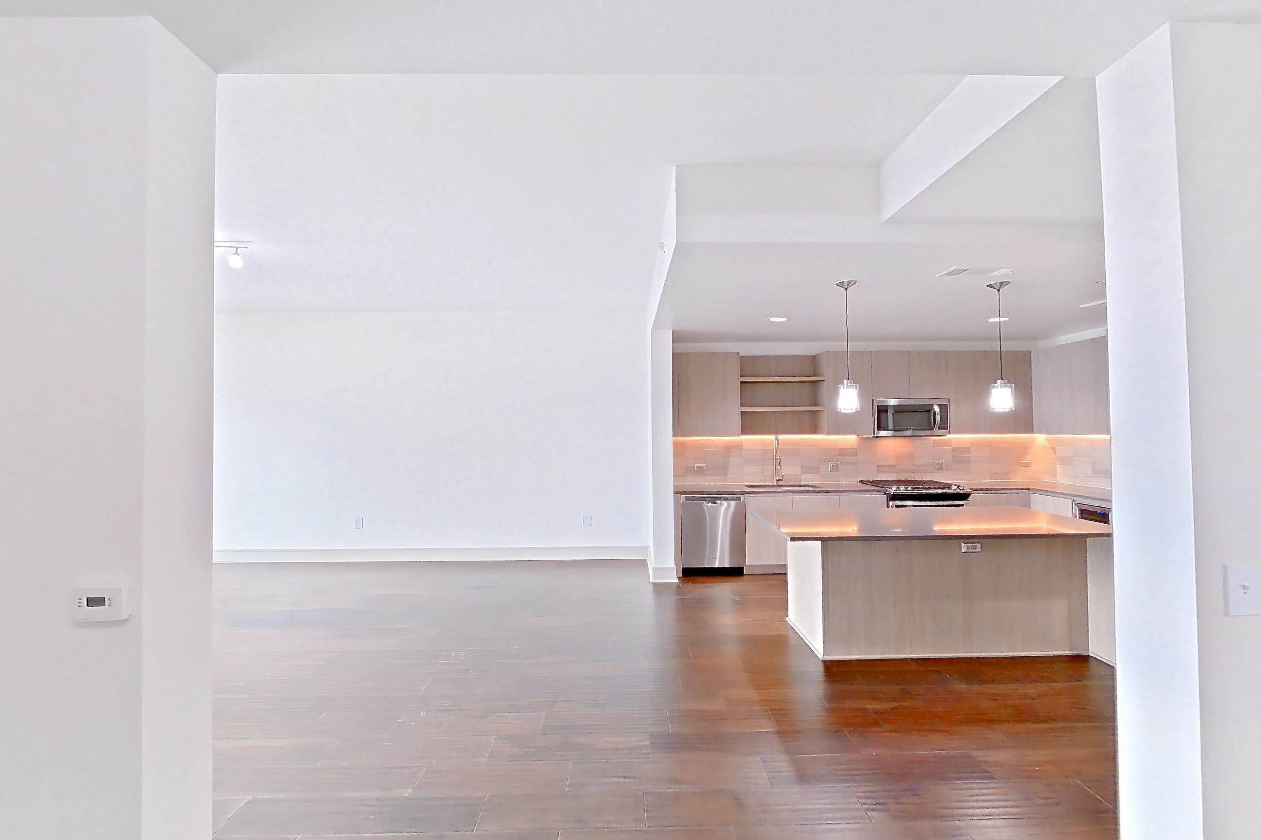 Dining space with dark wood-finish flooring, dishwasher, oven/range, stainless steel appliances, and wood-finish flooring, Apartment 1603 at Cortland Museum District