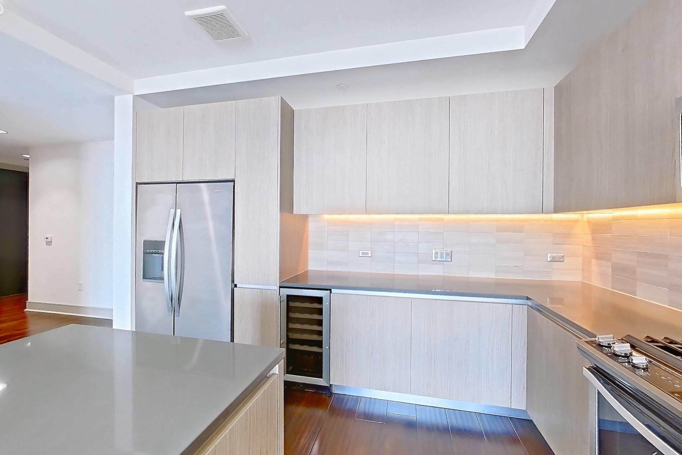 Kitchen with dark wood-finish flooring, gas range, microwave, oven/range, refrigerator, stainless steel appliances, water & ice dispenser, and wood-finish flooring, Apartment 1001 at Cortland Museum District