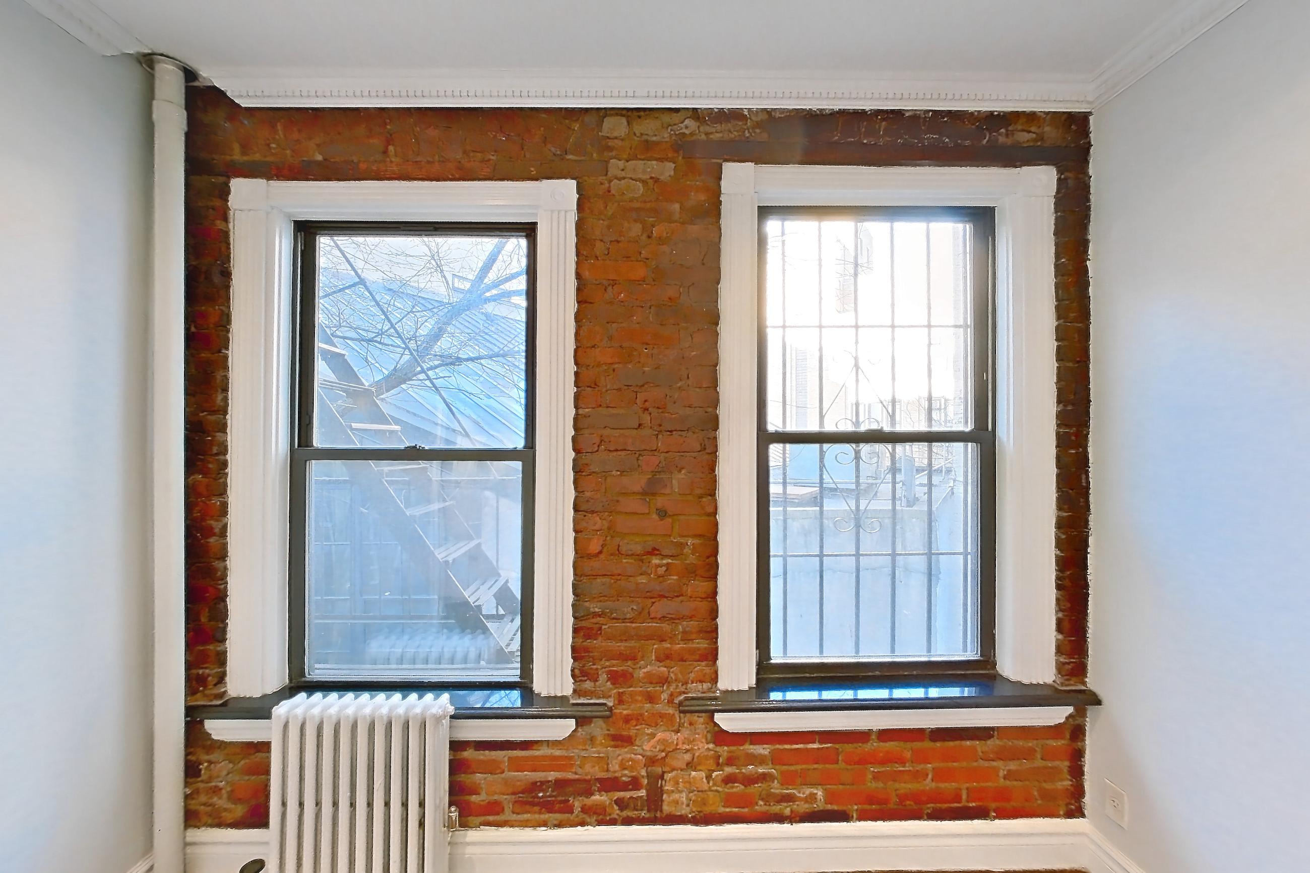 Living space with radiator heat and wood-finish flooring, Apartment 3F at Centennial Properties