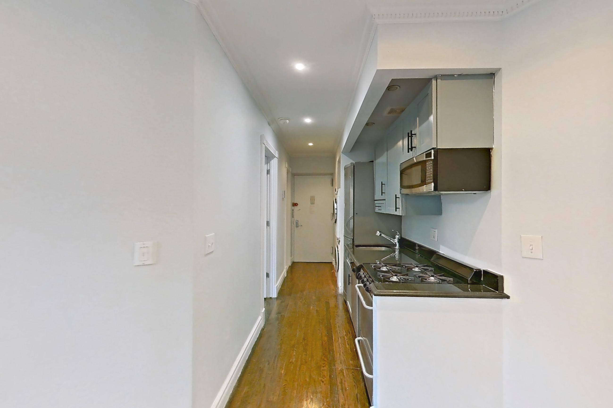 Living space with radiator heat and wood-finish flooring, Apartment 3F at Centennial Properties