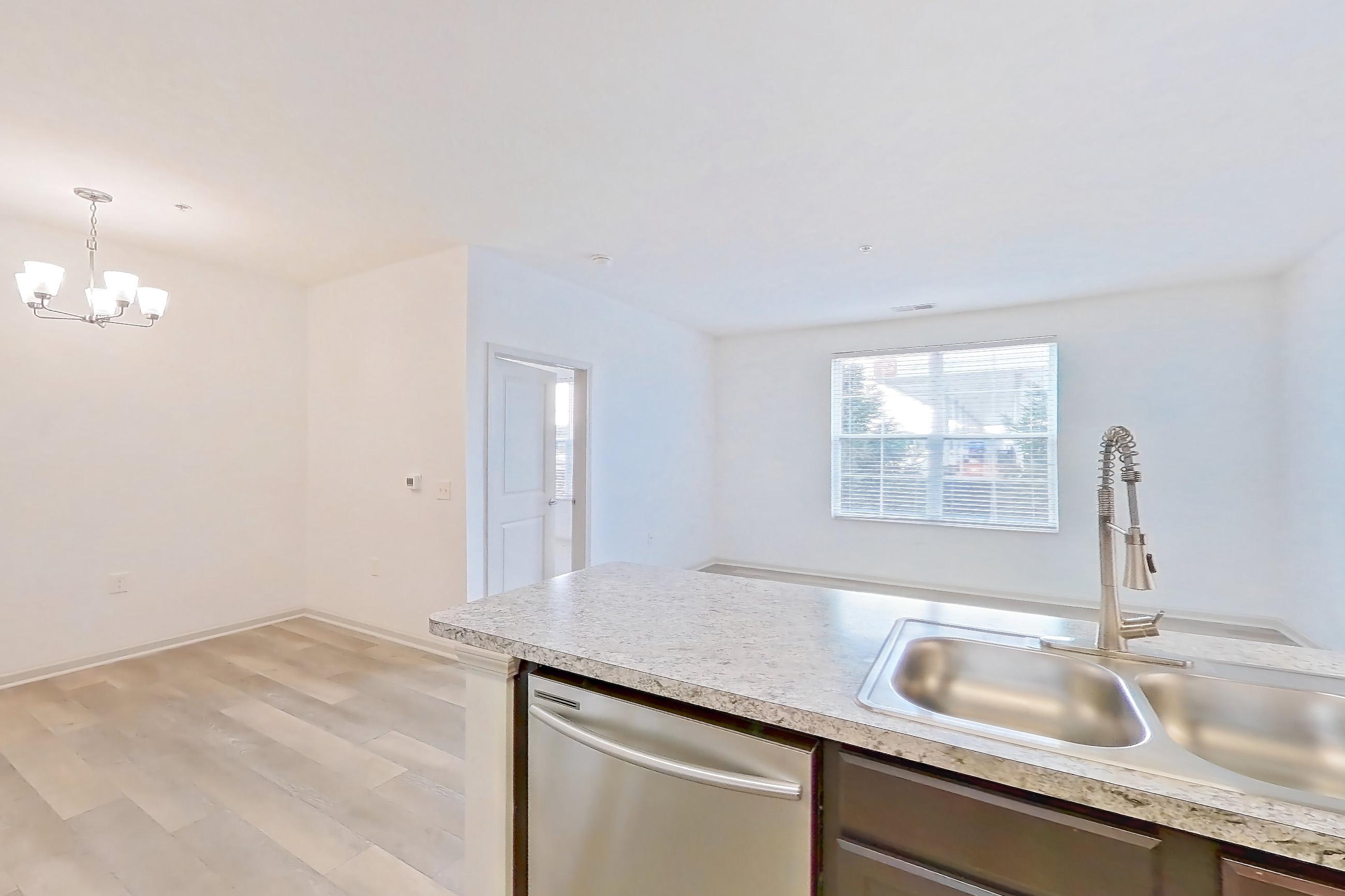 Kitchen with dishwasher, electric range, light countertops, light wood-finish flooring, microwave, oven/range, refrigerator, and stainless steel appliances, Apartment 102-4795 at Cortland Hilliard