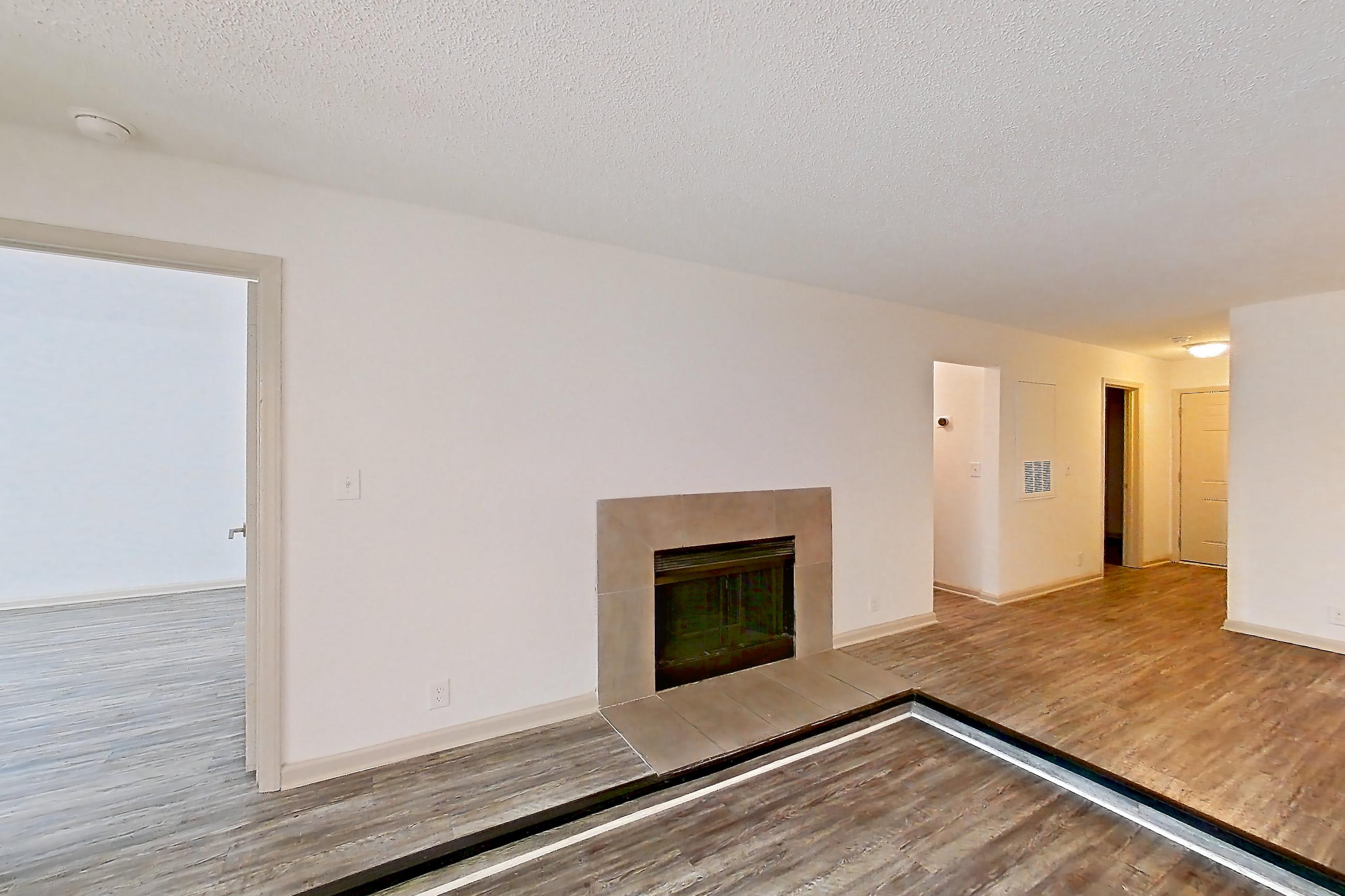 Living space with dark wood-finish flooring, fireplace, light wood-finish flooring, and tile fireplace, Apartment 3 at Cortland Cotswold