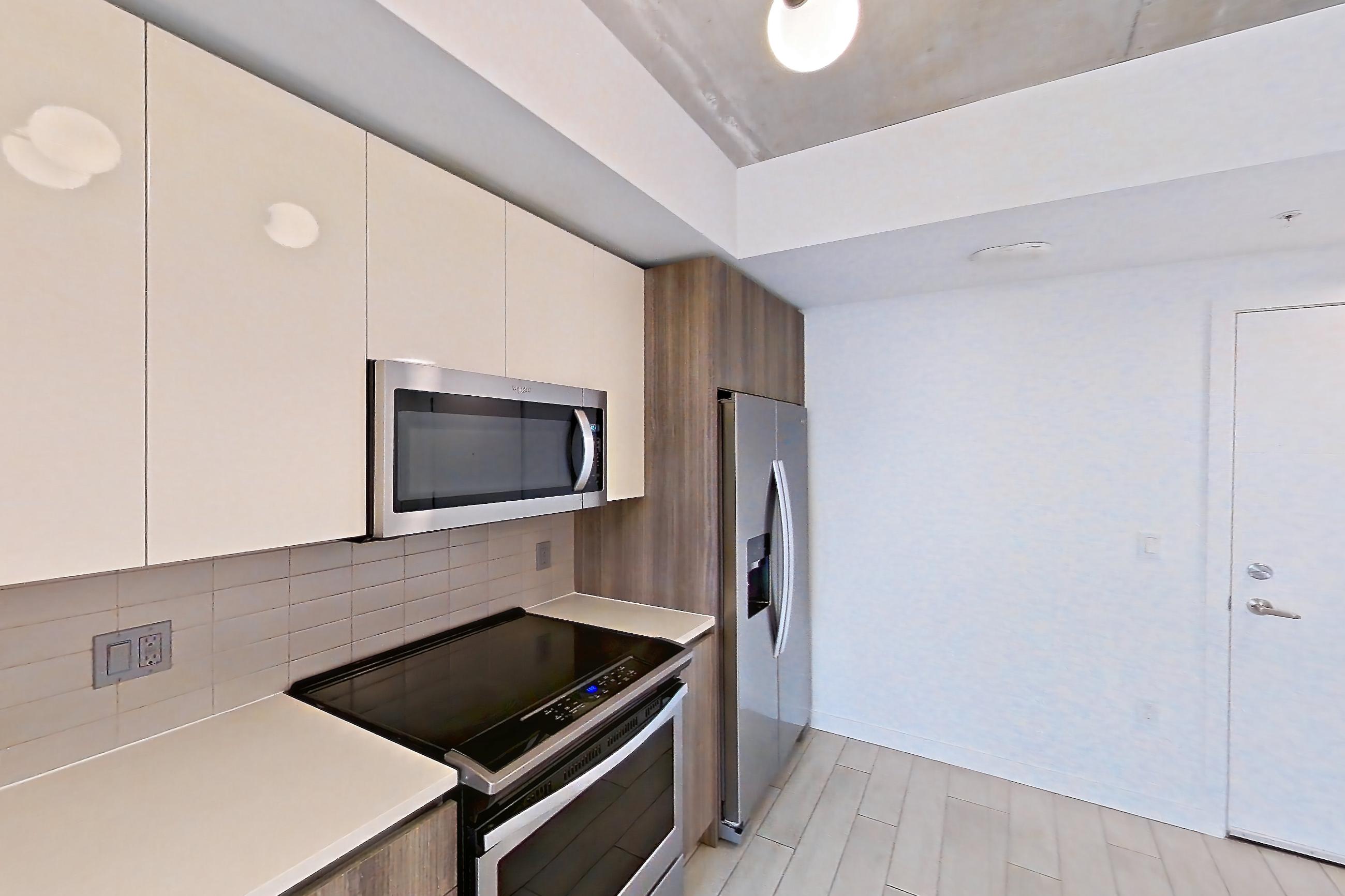 Kitchen with dishwasher, electric range, light countertops, light tile flooring, light wood-finish flooring, microwave, oven/range, refrigerator, stainless steel appliances, water & ice dispenser, and wood-look tile flooring, Apartment 1016 at Cortland Midtown Miami