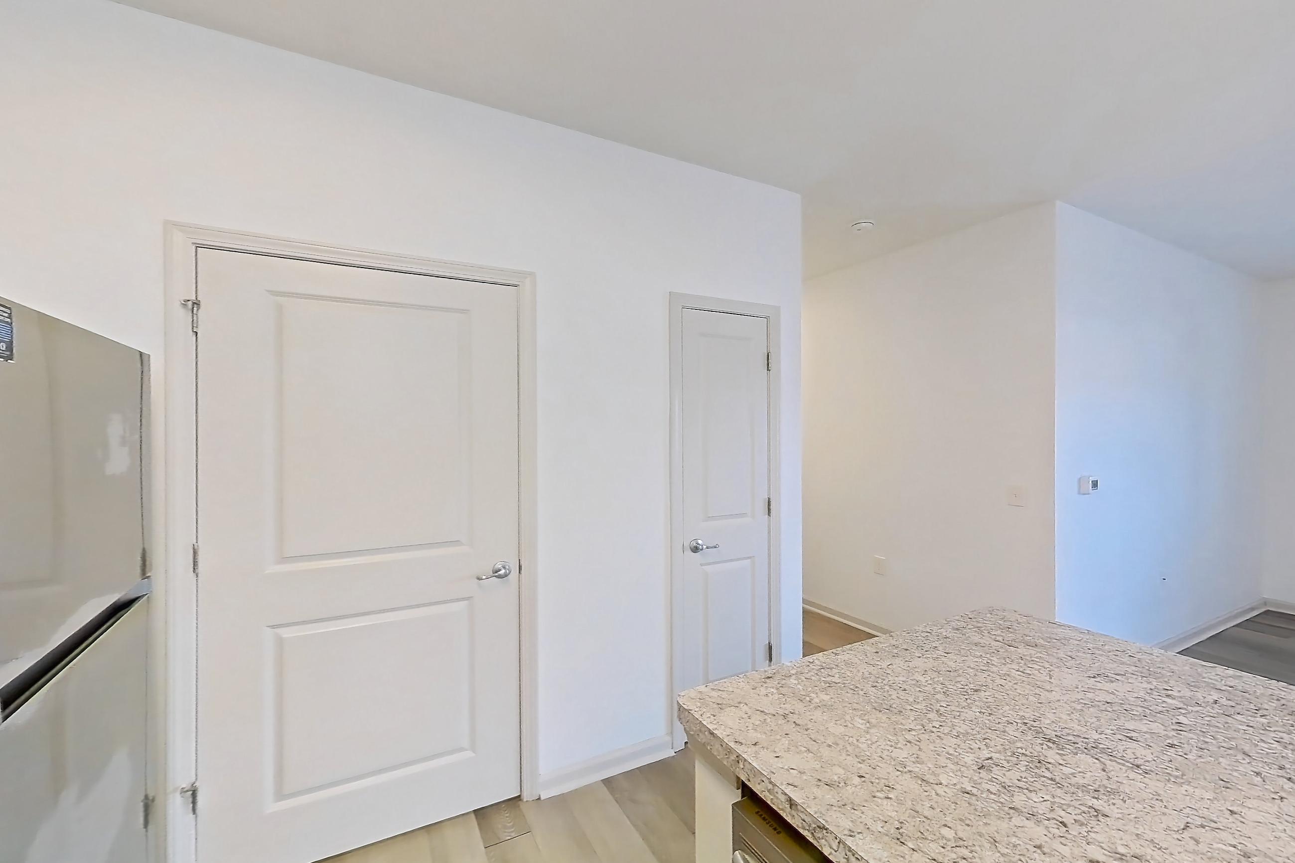 Kitchen with dishwasher, electric range, light countertops, light stone countertops, light wood-finish flooring, microwave, oven/range, refrigerator, and stainless steel appliances, Apartment 108-4839 at Cortland Hilliard