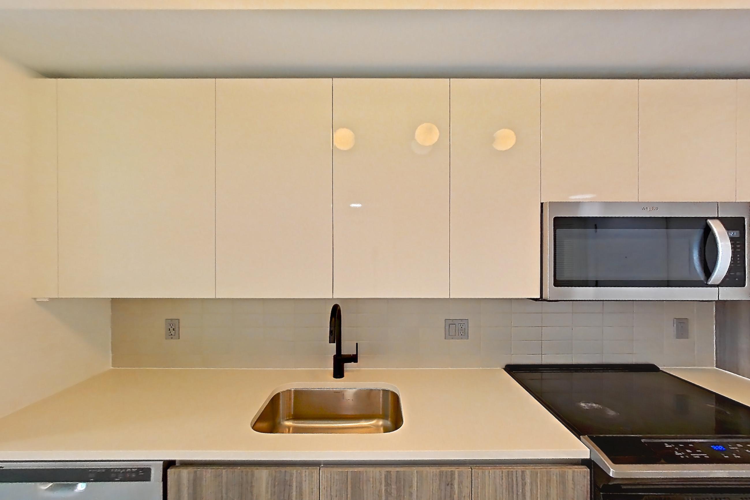 Kitchen with dishwasher, electric range, light countertops, light tile flooring, light wood-finish flooring, microwave, oven/range, refrigerator, stainless steel appliances, water & ice dispenser, and wood-look tile flooring, Apartment 2416 at Cortland Midtown Miami