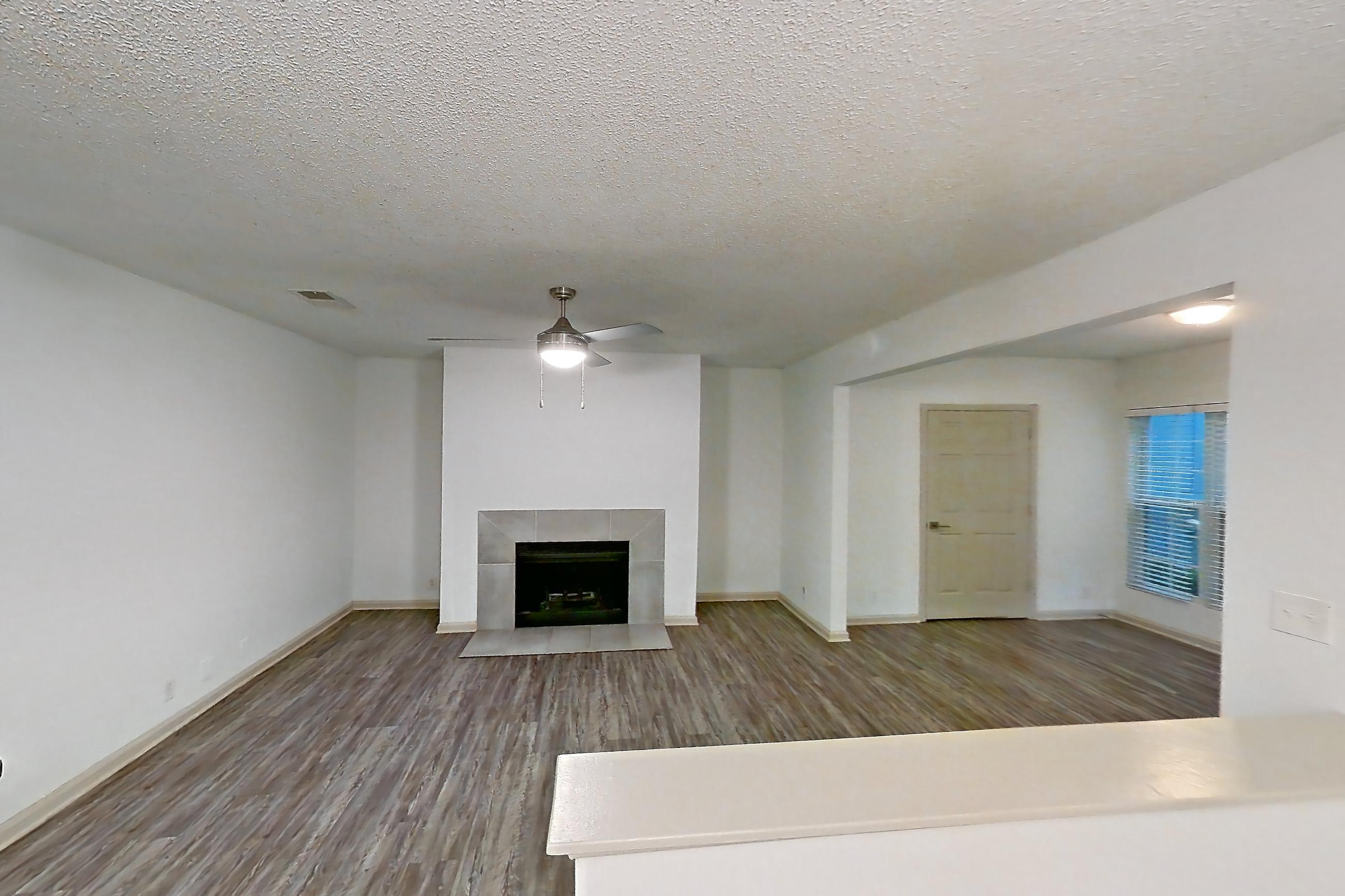 Dining room with dark stone countertops, dark wood-finish flooring, electric range, fireplace, oven/range, stainless steel appliances, and tile fireplace, Apartment 4 at Cortland Cotswold