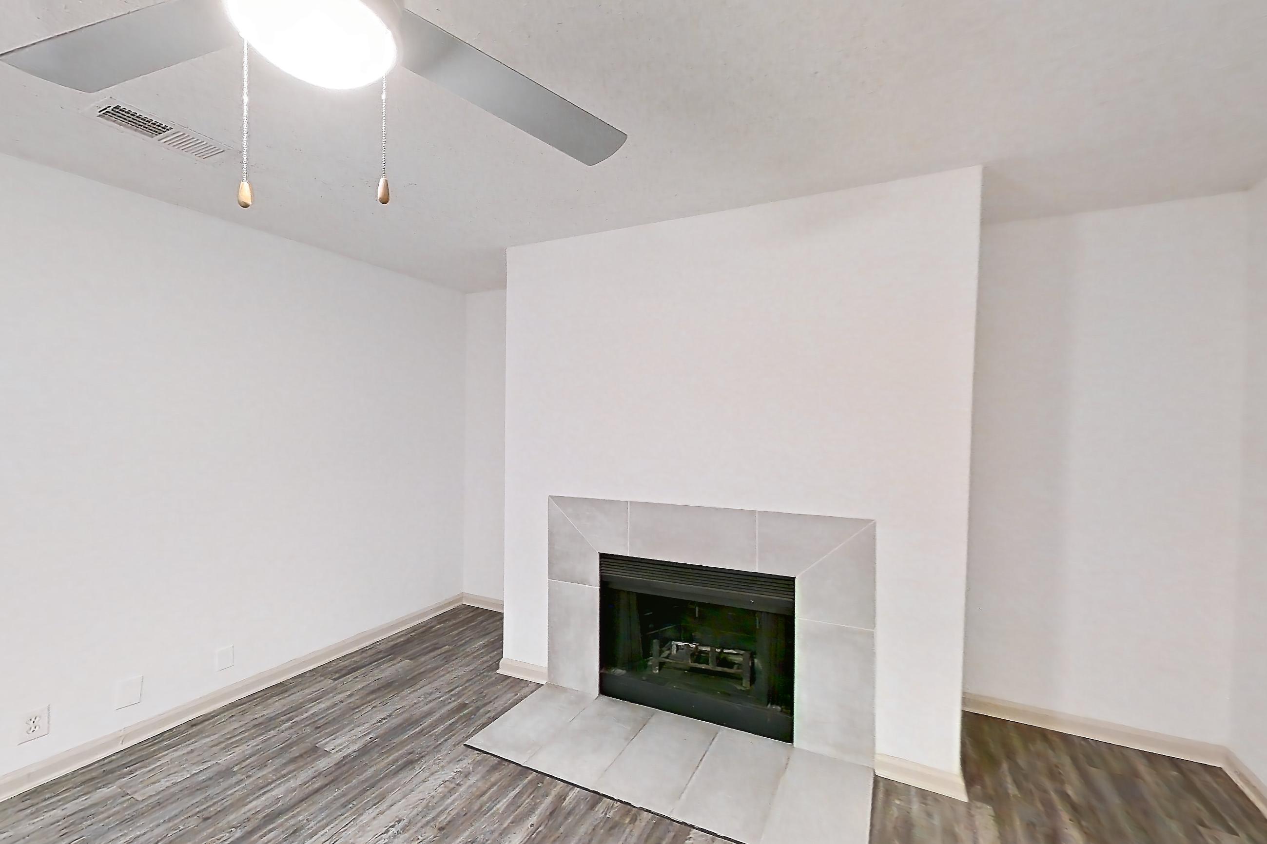 Living space with fireplace, light wood-finish flooring, and tile fireplace, Apartment 4 at Cortland Cotswold