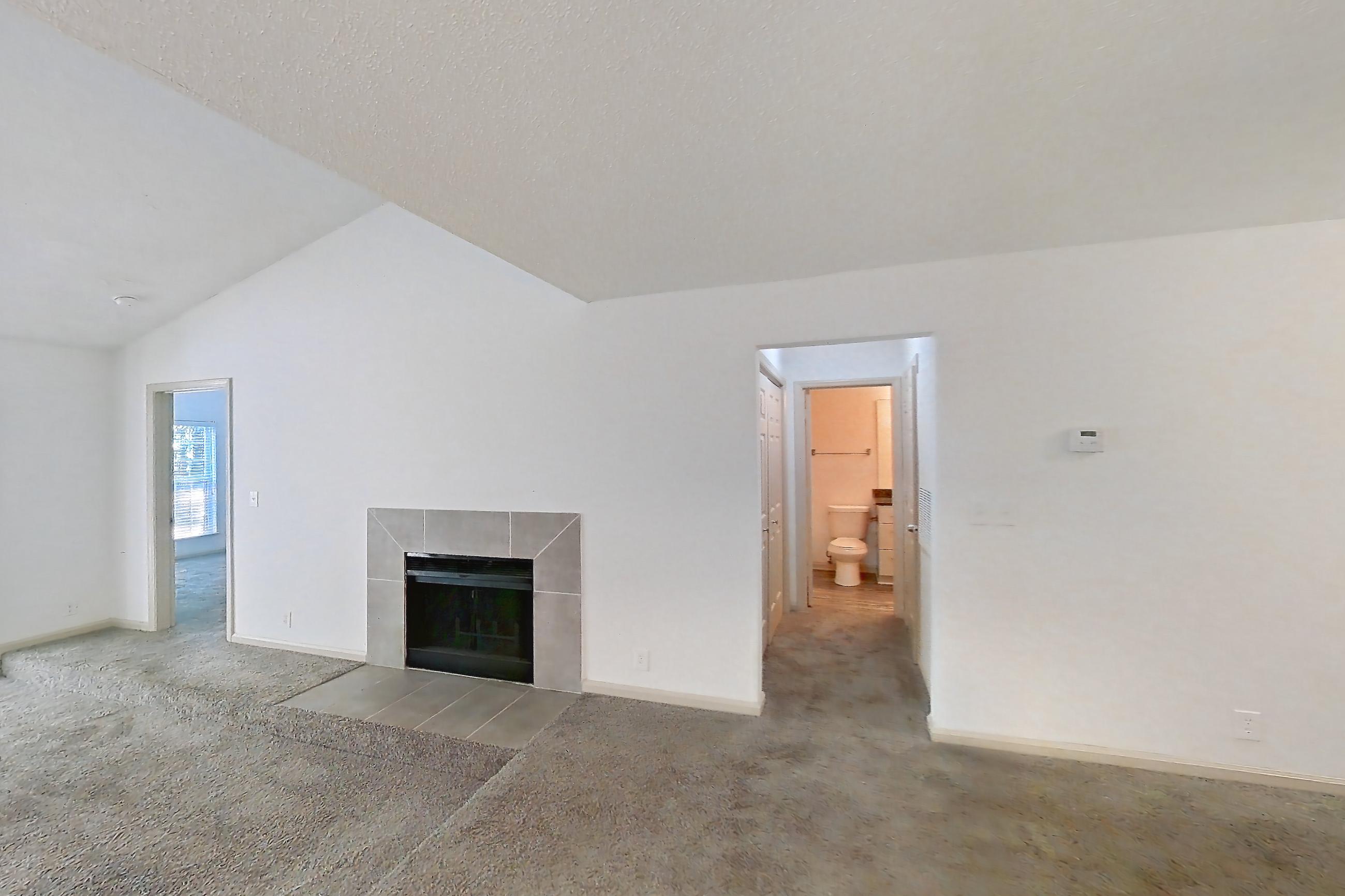 Dining room with dark stone countertops, dishwasher, electric range, fireplace, light carpet, light countertops, oven/range, refrigerator, stainless steel appliances, and tile fireplace, Apartment 9 at Cortland Cotswold
