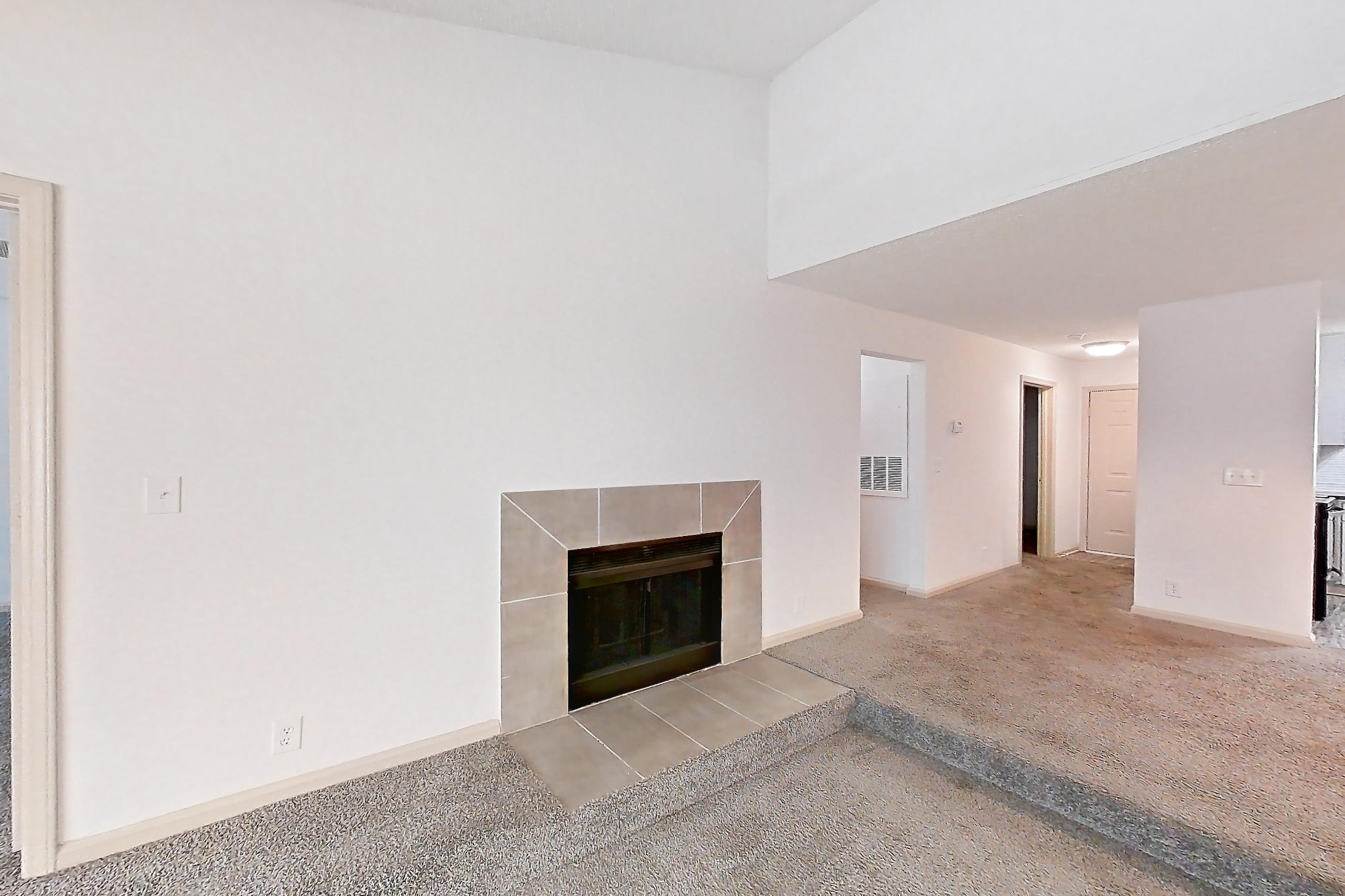 Living space with dishwasher, fireplace, stainless steel appliances, and tile fireplace, Apartment 9 at Cortland Cotswold