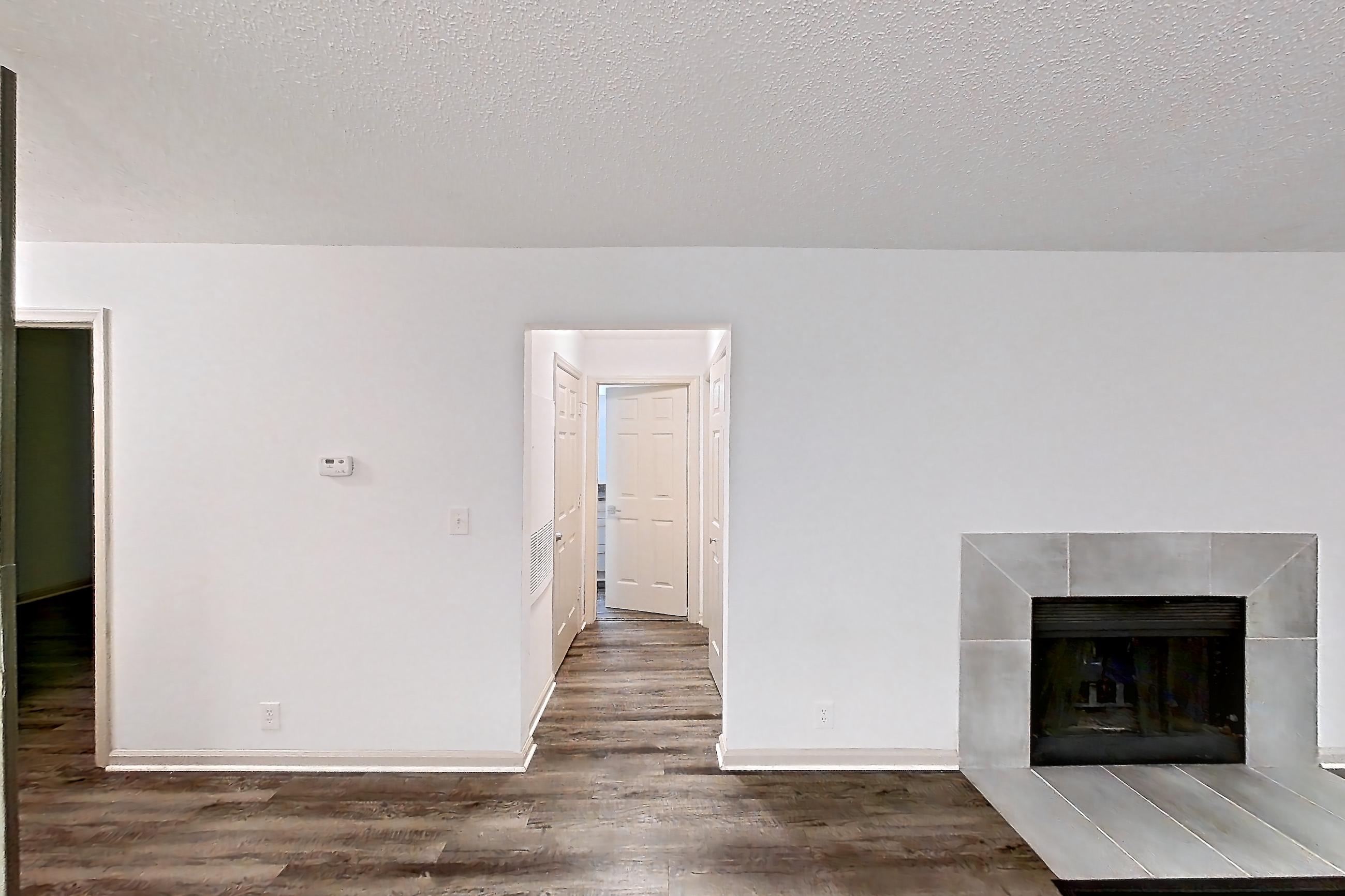 Dining room with dark stone countertops, dark wood-finish flooring, dishwasher, electric range, fireplace, light wood-finish flooring, refrigerator, stainless steel appliances, and tile fireplace, Apartment 2 at Cortland Cotswold