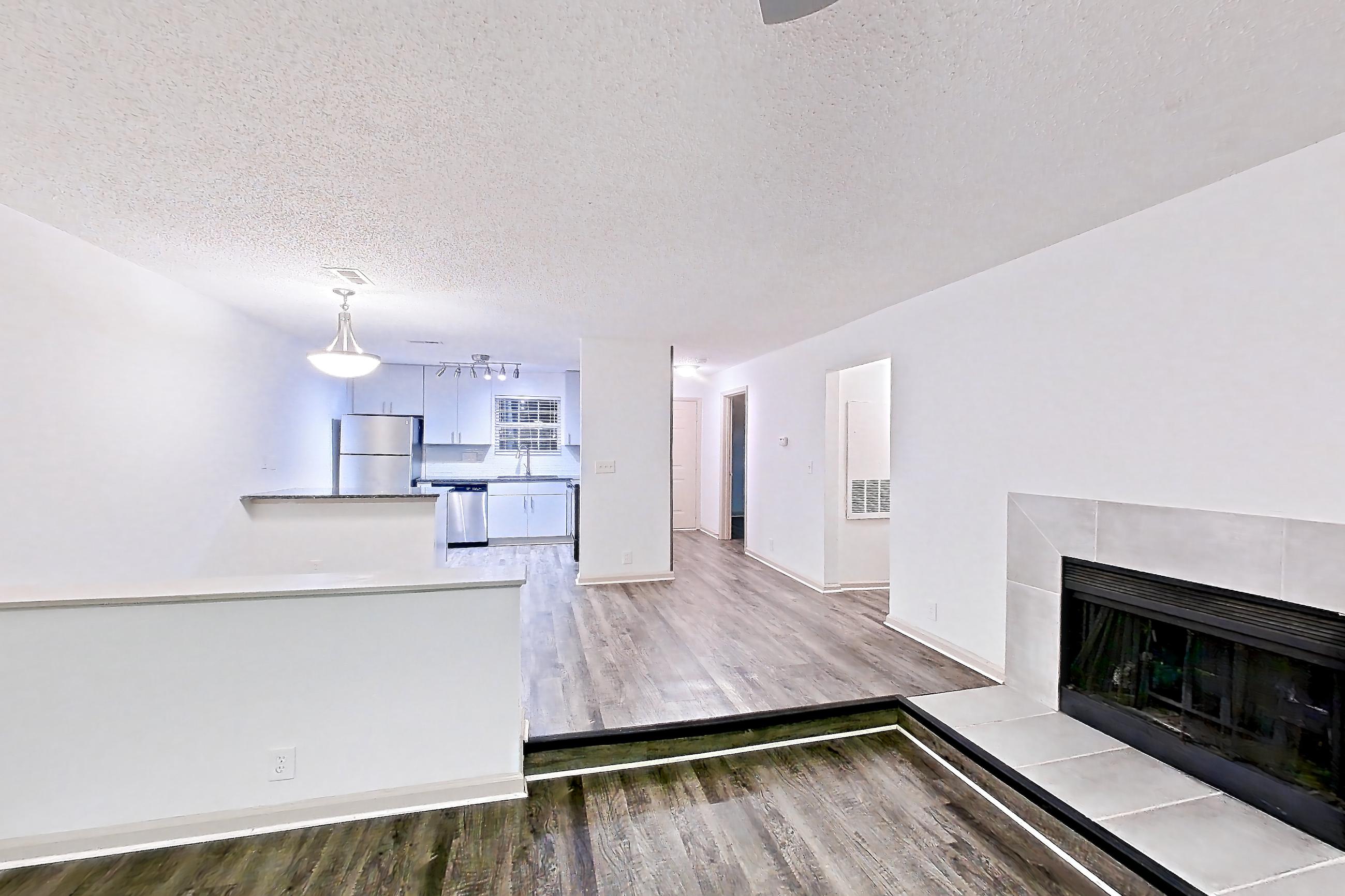 Living space with dark wood-finish flooring, fireplace, and tile fireplace, Apartment 2 at Cortland Cotswold