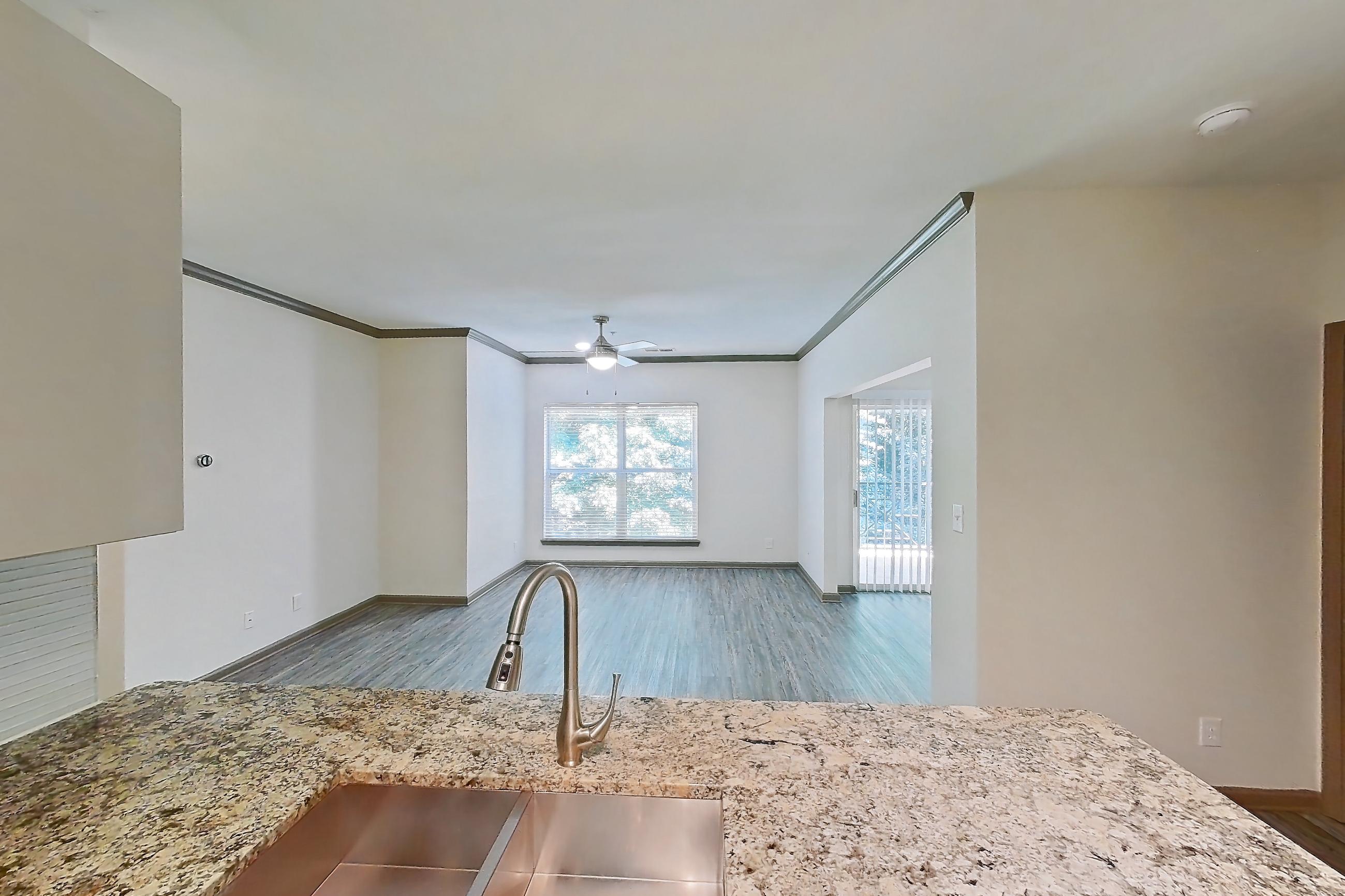 Kitchen with dishwasher, electric range, light countertops, light stone countertops, light wood-finish flooring, microwave, oven/range, and stainless steel appliances, Apartment 1337 at Cortland Seventy Seven