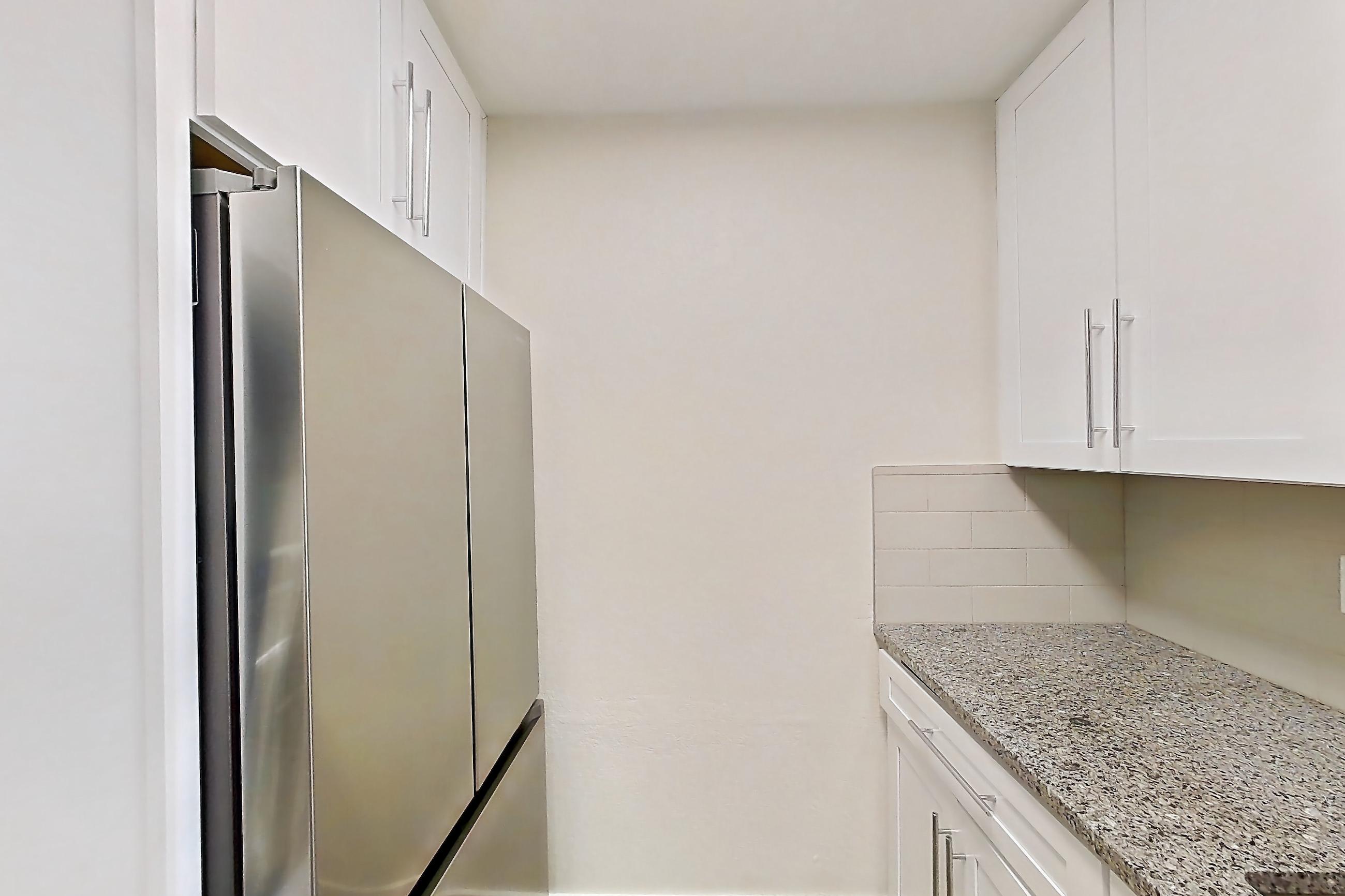 Kitchen with dishwasher, electric range, light countertops, light stone countertops, light wood-finish flooring, microwave, oven/range, refrigerator, and stainless steel appliances, Apartment 226 at Cortland Sun River