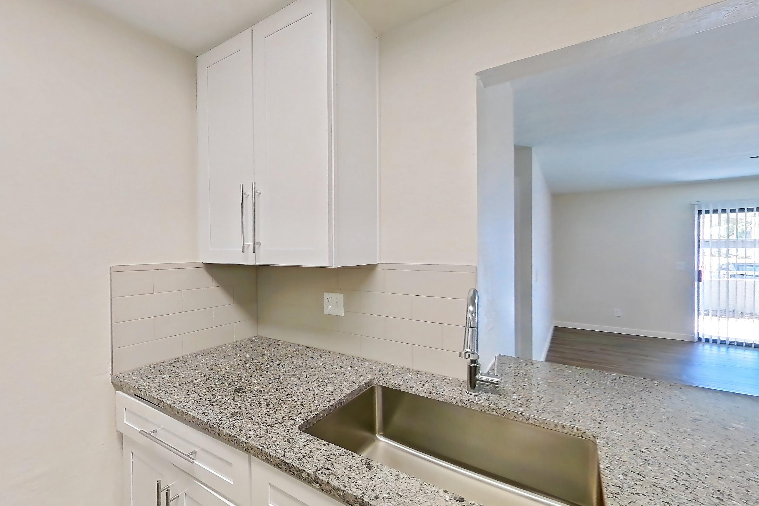 Kitchen with dishwasher, electric range, light countertops, light stone countertops, light wood-finish flooring, microwave, oven/range, refrigerator, and stainless steel appliances, Apartment 226 at Cortland Sun River
