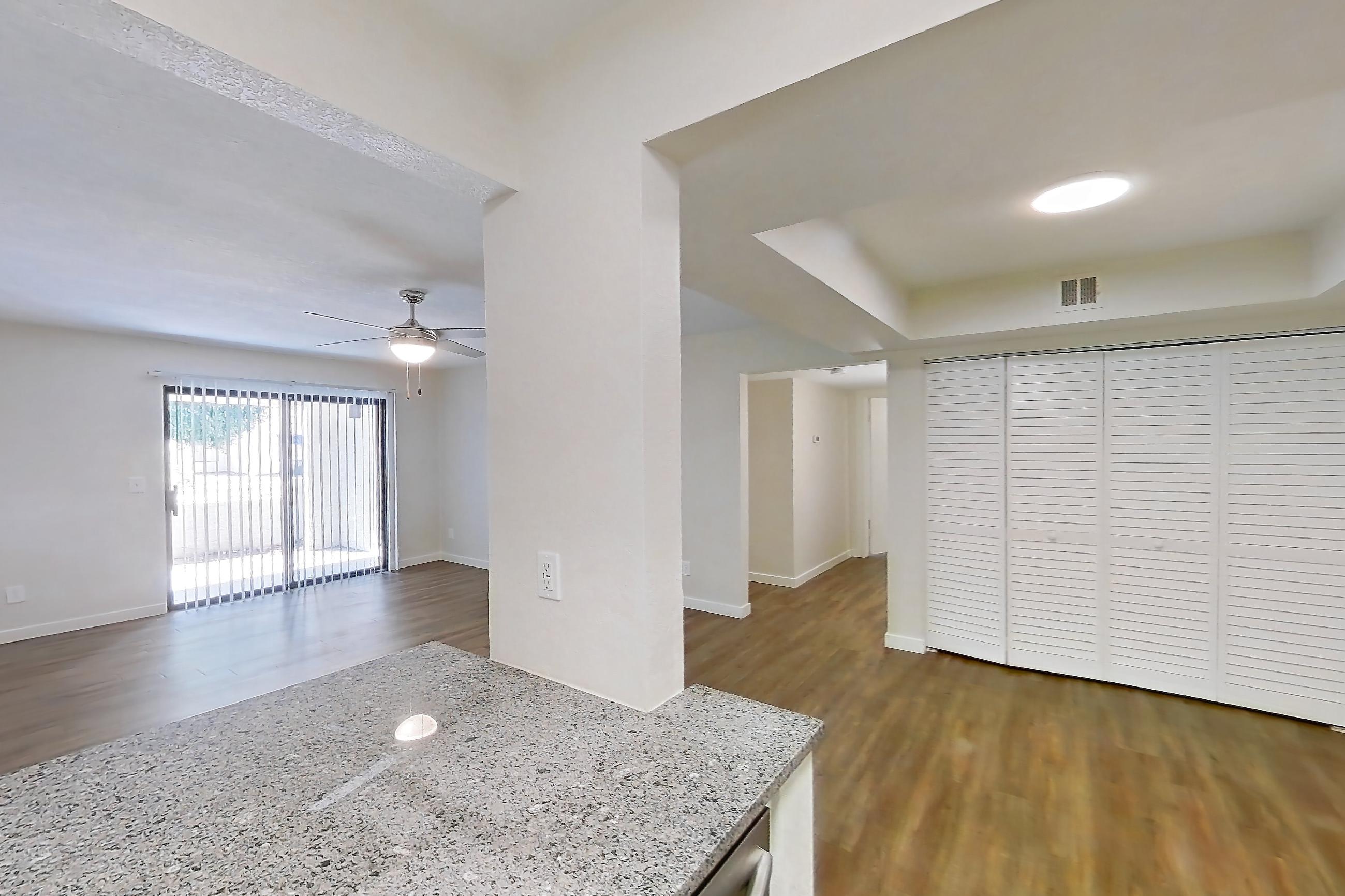 Kitchen with dishwasher, light countertops, light stone countertops, light wood-finish flooring, oven/range, refrigerator, and stainless steel appliances, Apartment 250 at Cortland Sun River