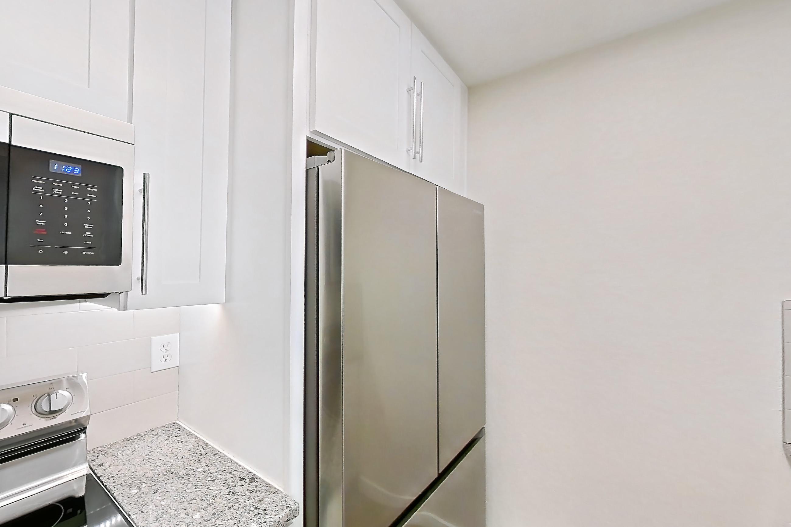 Kitchen with dishwasher, light countertops, light stone countertops, light wood-finish flooring, oven/range, refrigerator, and stainless steel appliances, Apartment 250 at Cortland Sun River