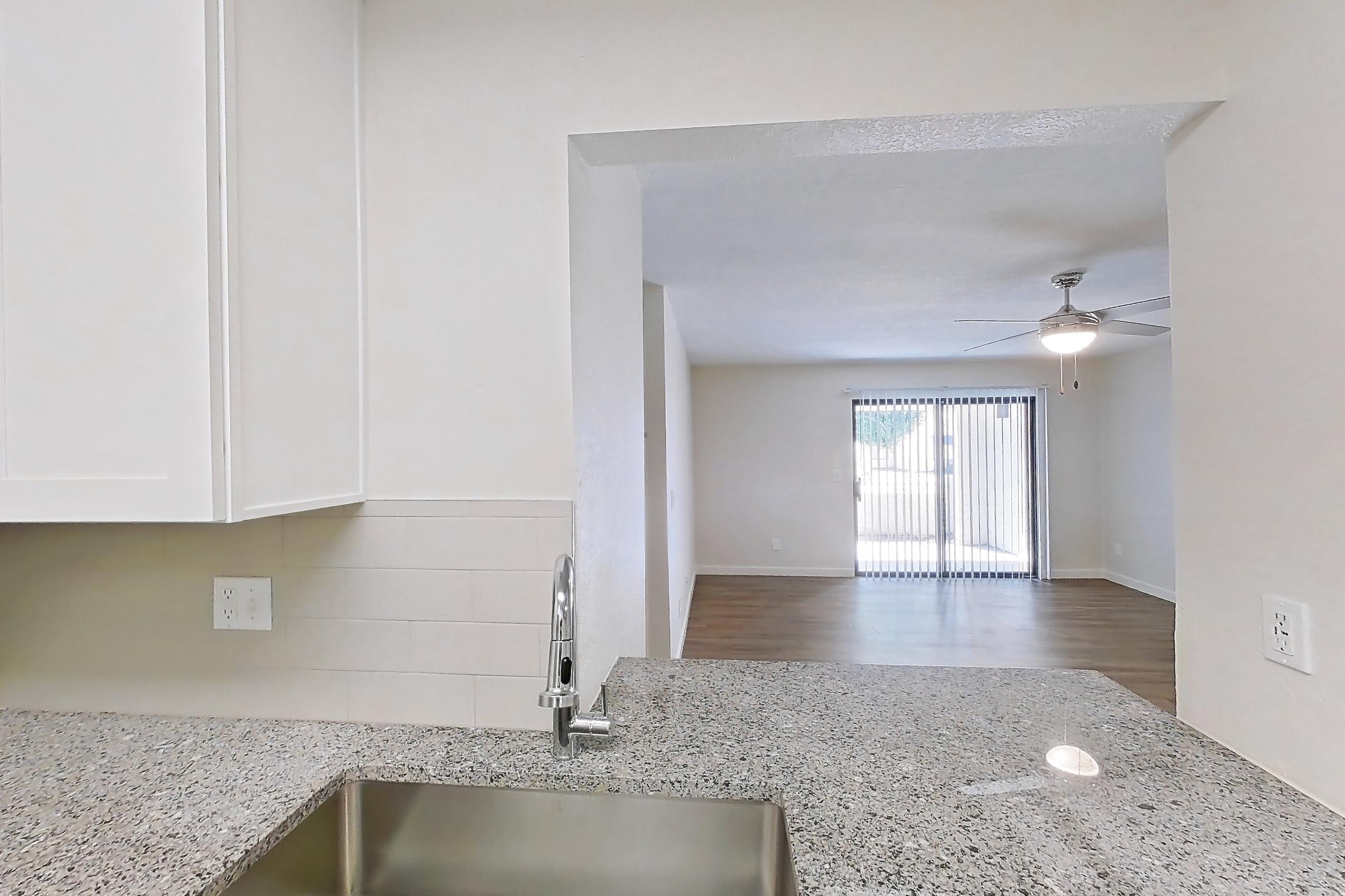 Kitchen with dishwasher, light countertops, light stone countertops, light wood-finish flooring, oven/range, refrigerator, and stainless steel appliances, Apartment 250 at Cortland Sun River