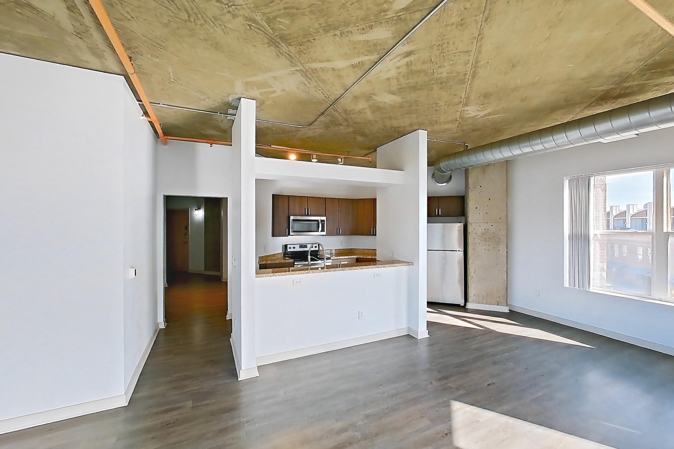 Living space with dark wood-finish flooring, electric range, oven/range, refrigerator, and stainless steel appliances, Apartment 1430 at Cortland on Blake