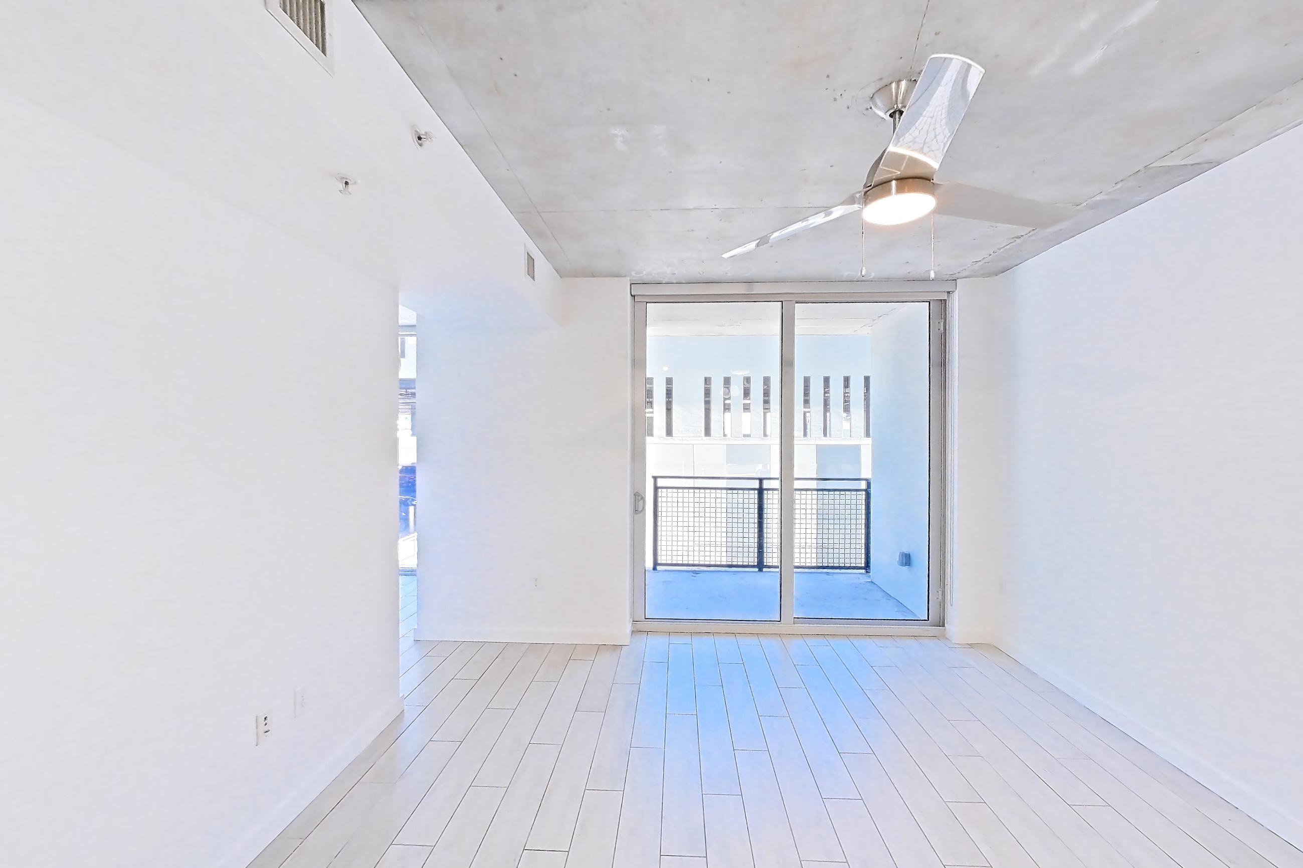Kitchen island corner with light countertops, light wood-finish flooring, and wood-look tile flooring, Apartment 0907 at Cortland Midtown Miami