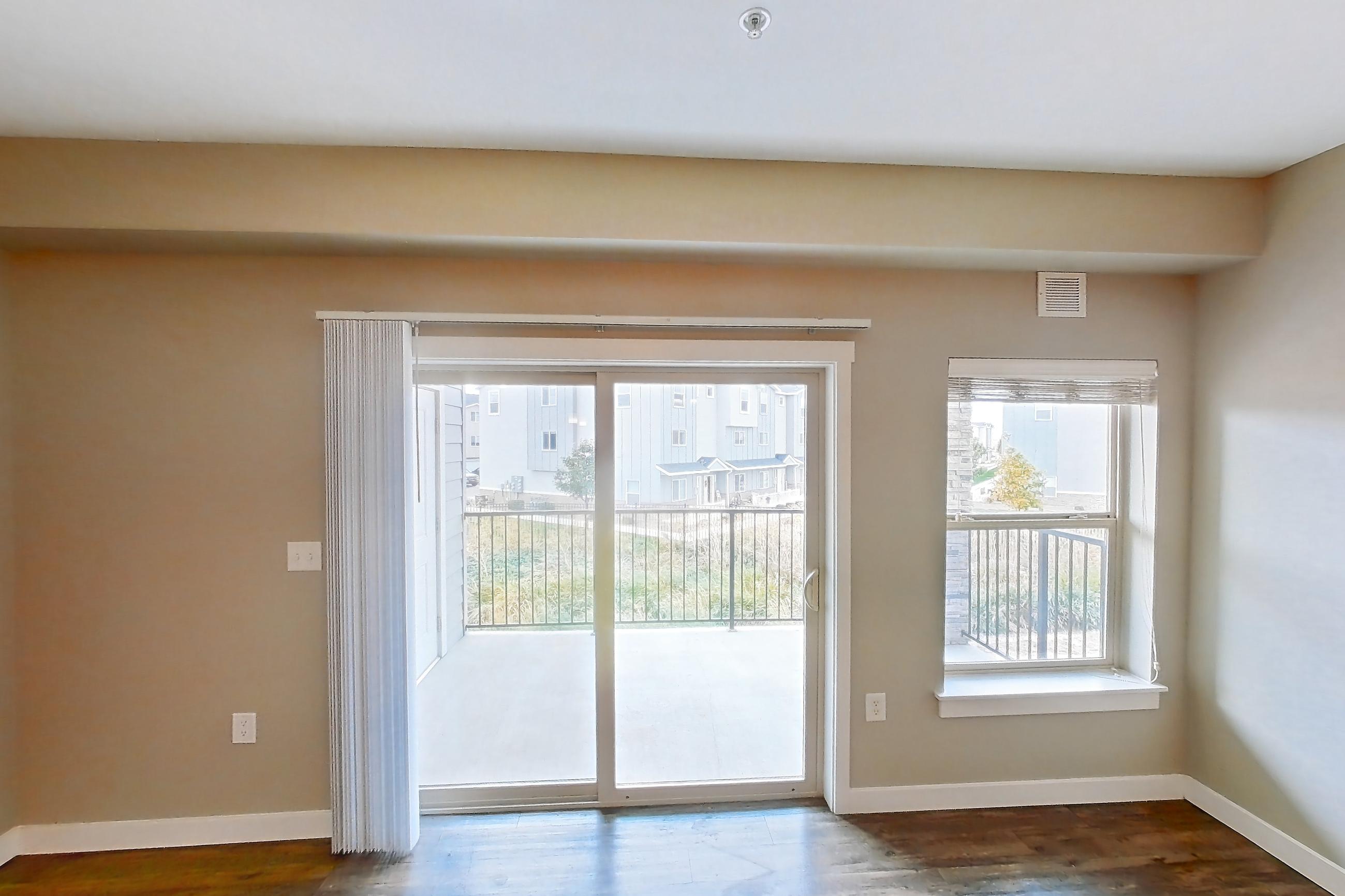 Living room with dark wood-finish flooring, Apartment B208 at Cortland at Ten Mile