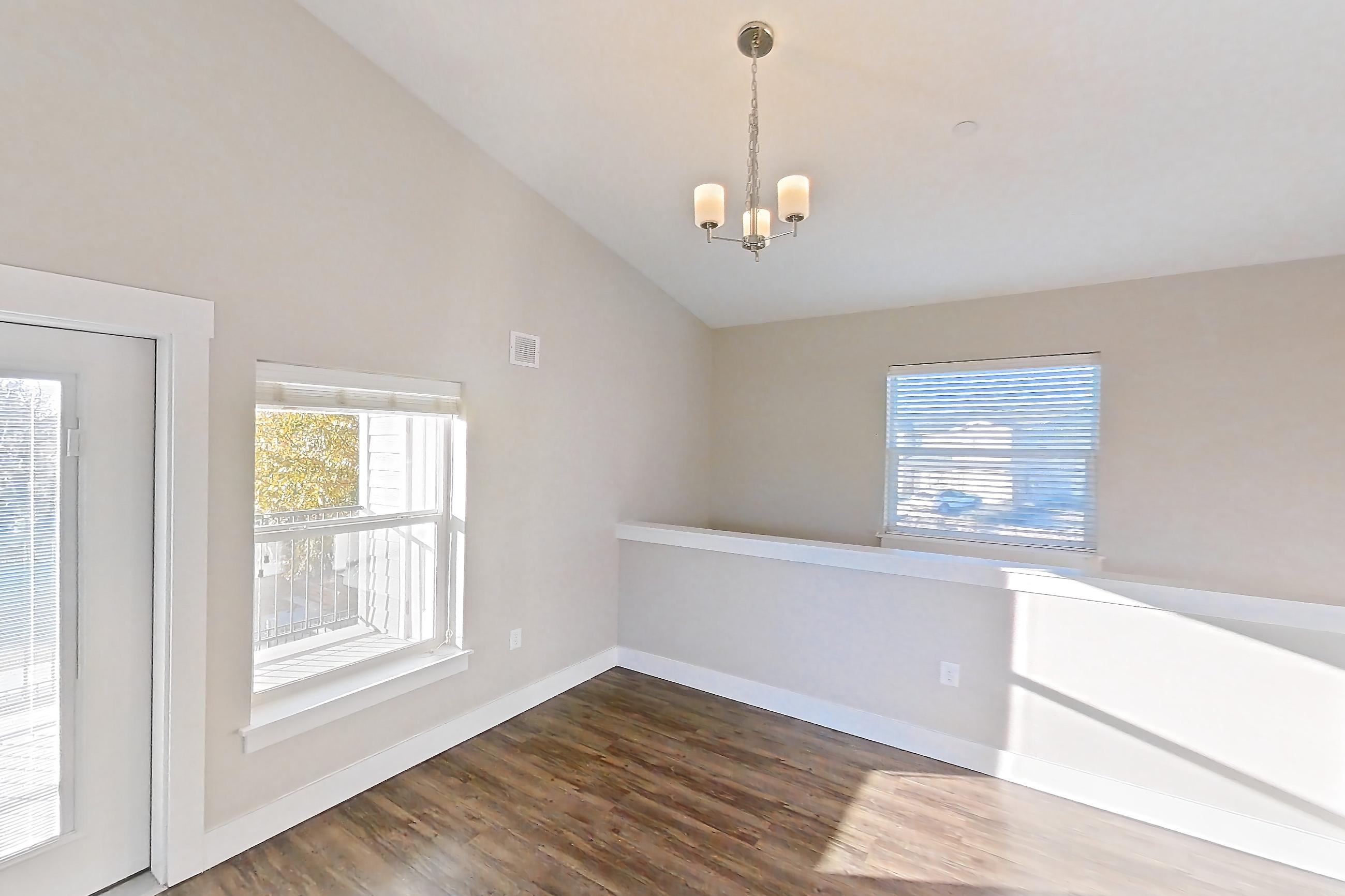 Living room with dark wood-finish flooring, Apartment E101 at Cortland at Ten Mile