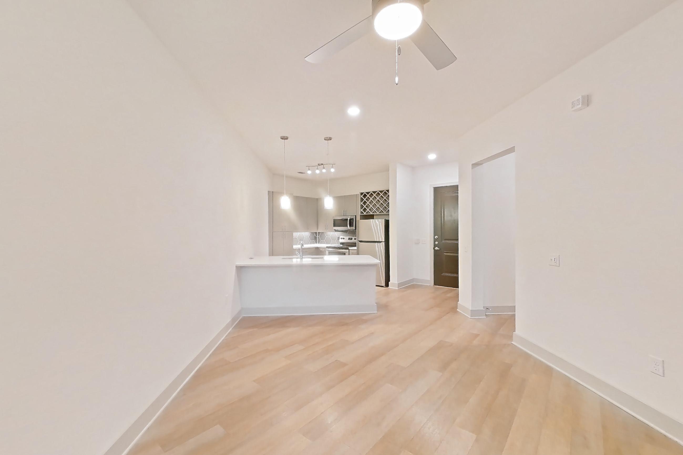 Living space with light wood-finish flooring, refrigerator, and stainless steel appliances, Apartment 7408 at Cortland Satori