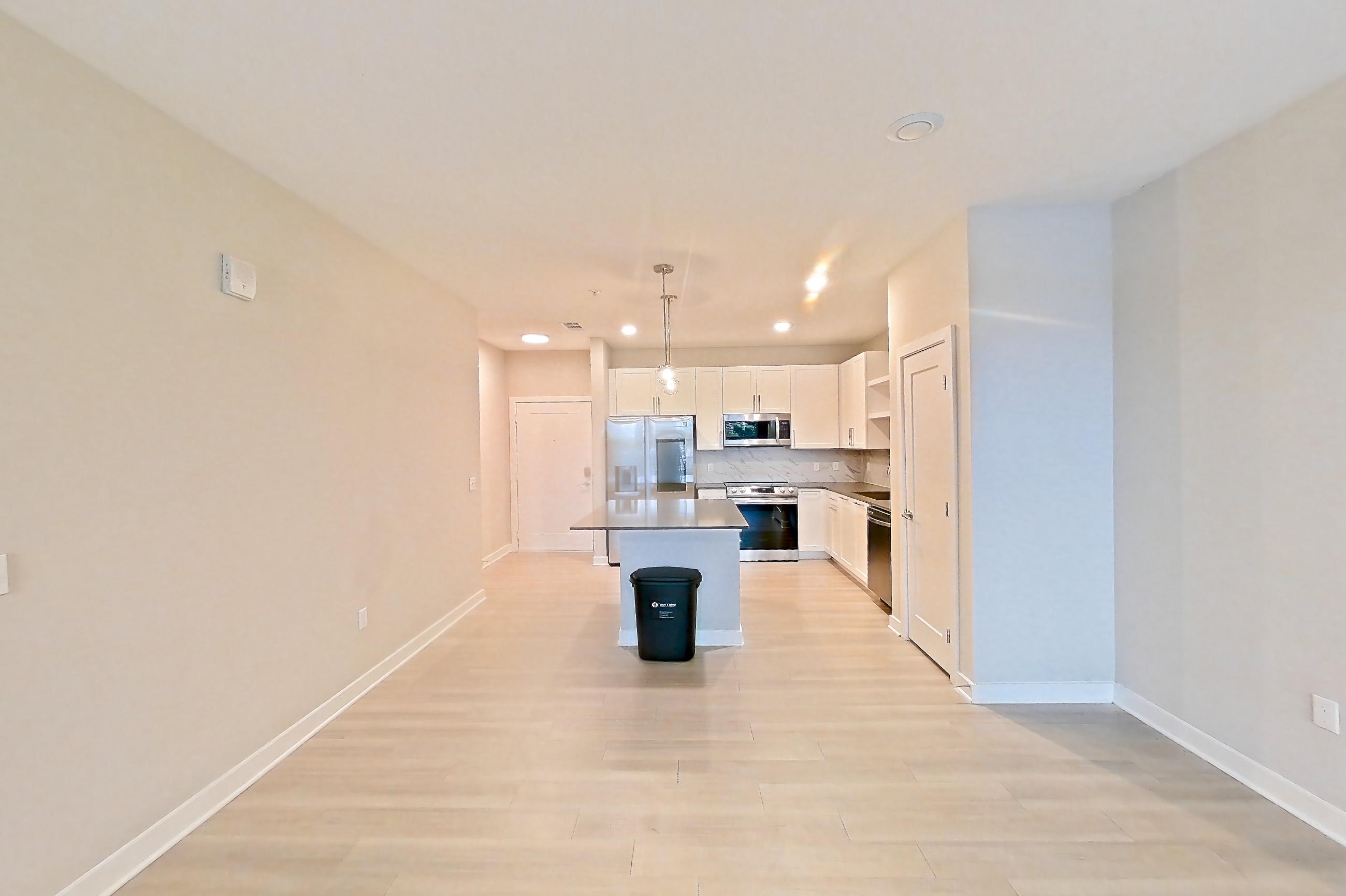 Living room with dishwasher, electric range, light countertops, light wood-finish flooring, oven/range, and stainless steel appliances, Apartment 2114 at Cortland Nona