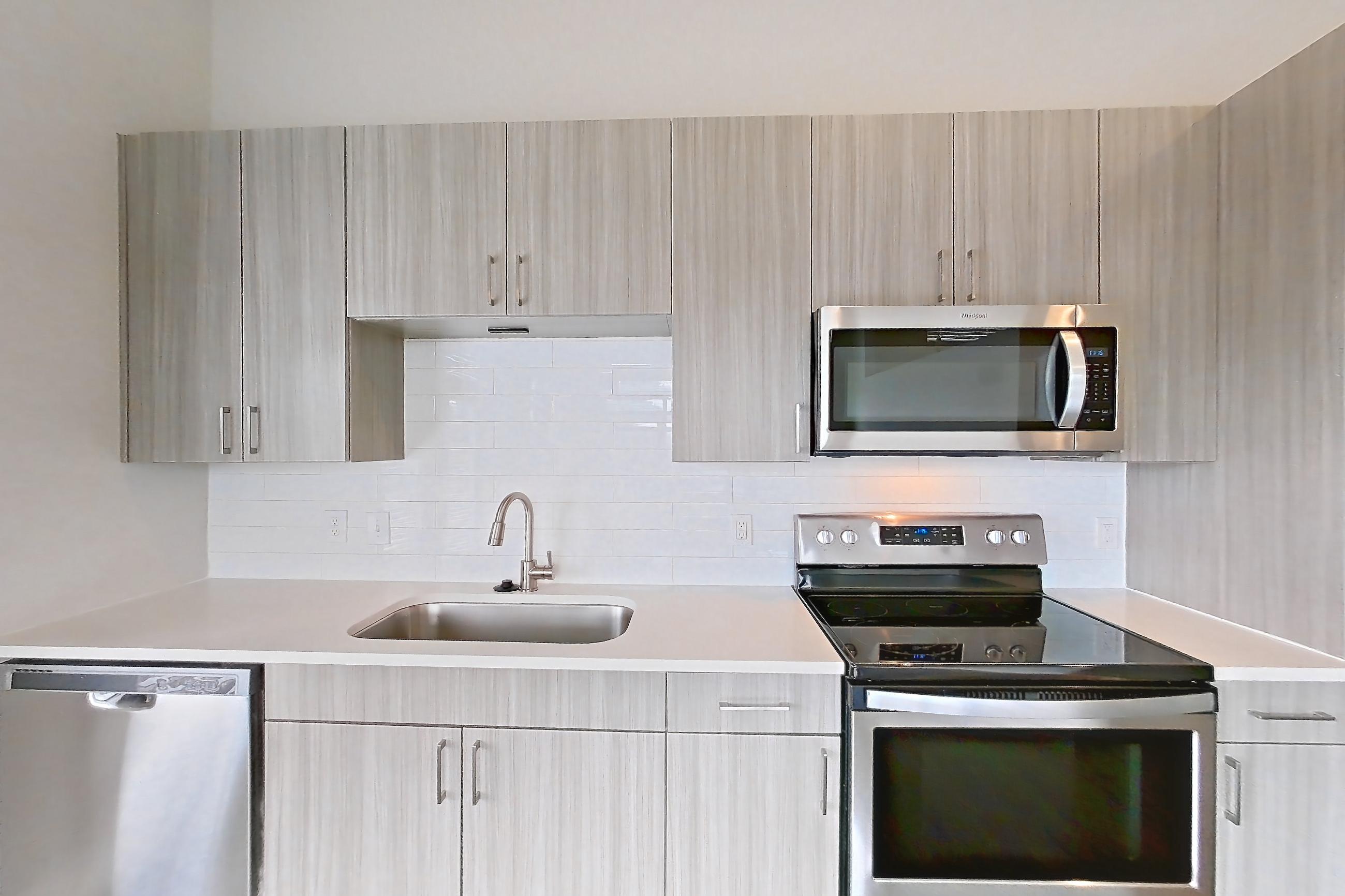 Kitchen with light stone countertops, Apartment 303 at Cortland NoDa