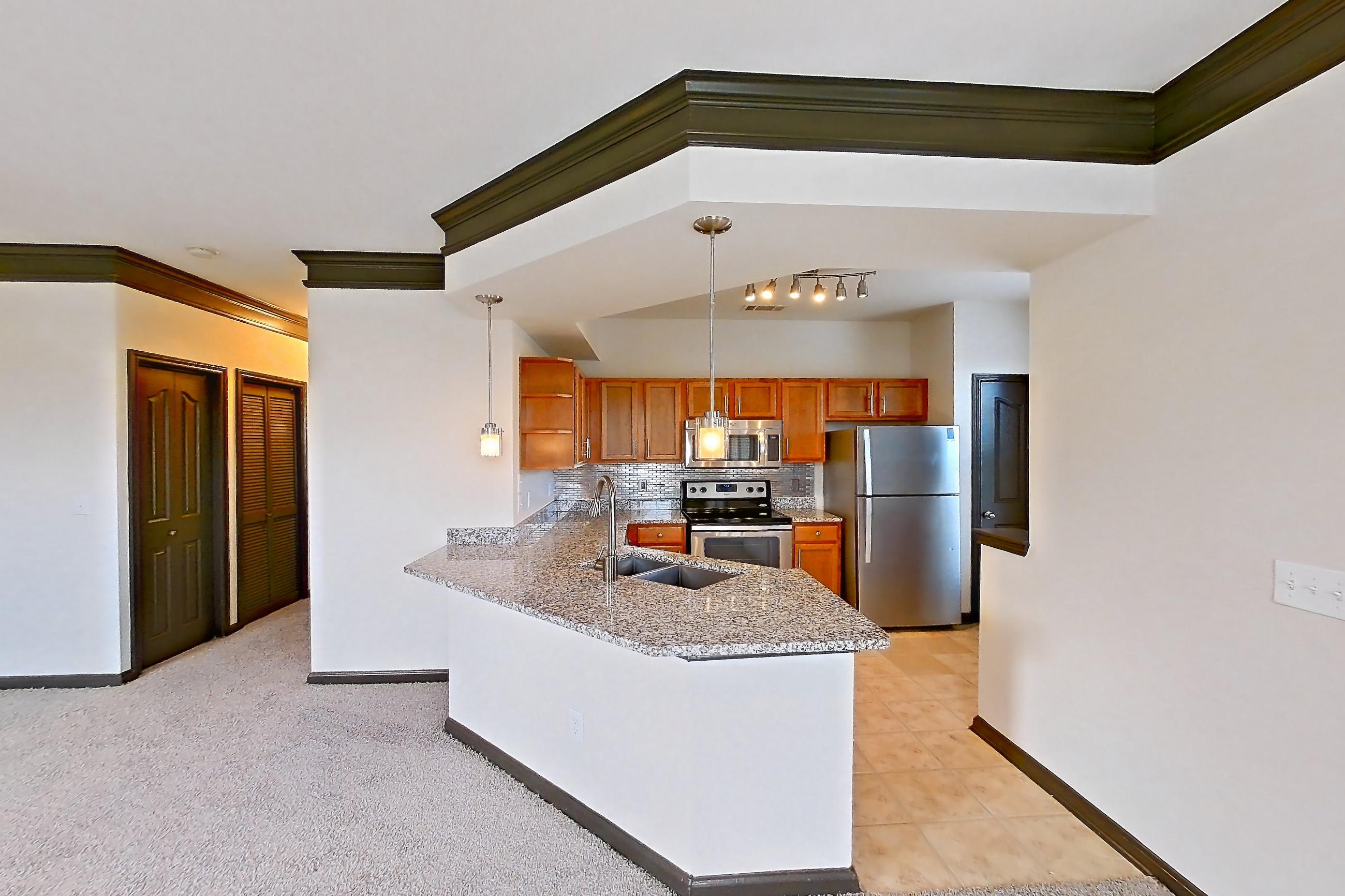 Dining room with electric range, light carpet, light stone countertops, oven/range, refrigerator, and stainless steel appliances, Apartment 1-939 at Cortland Ridglea