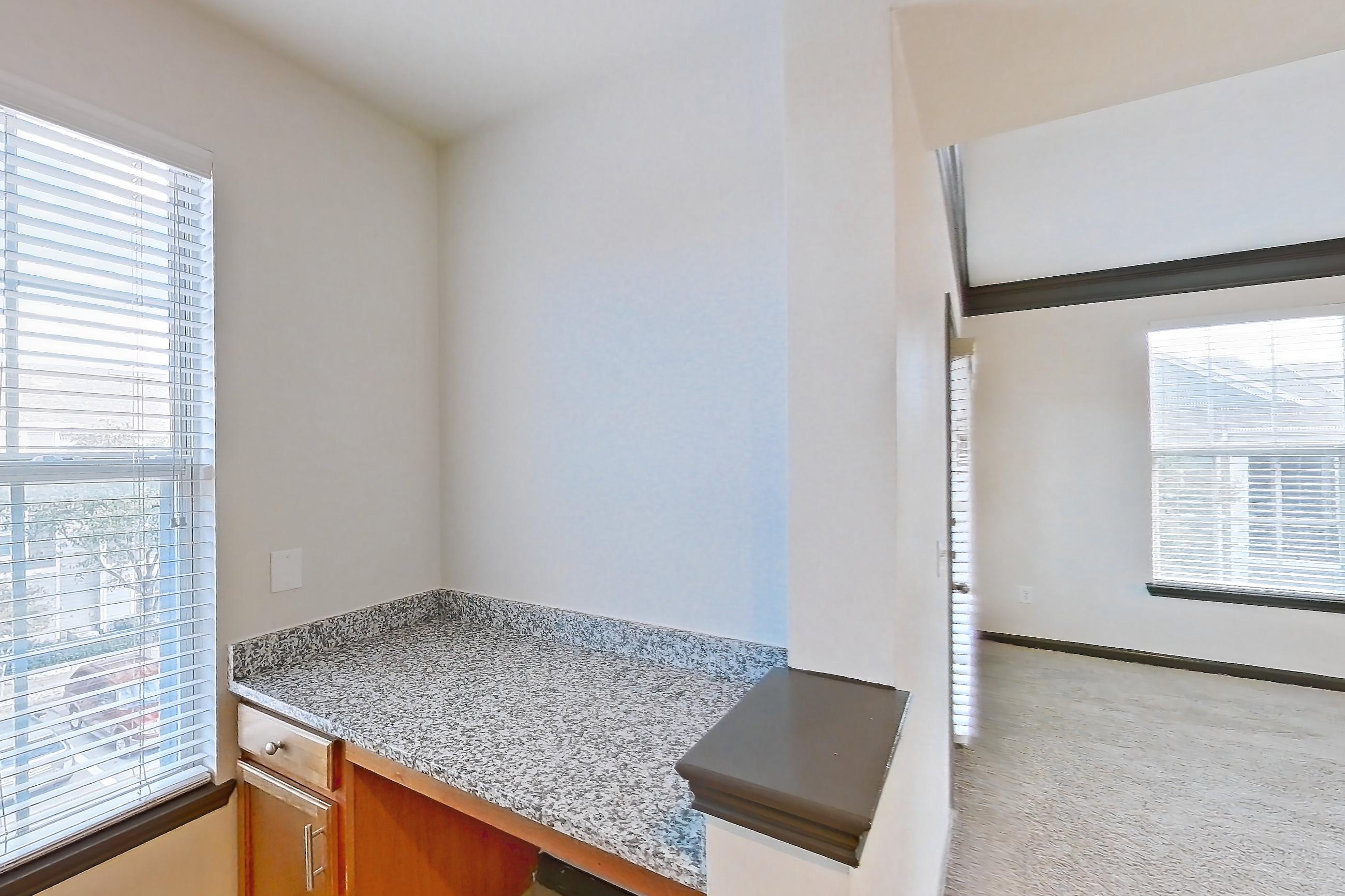 Kitchen with dishwasher, electric range, light carpet, light countertops, light stone countertops, light tile flooring, microwave, oven/range, refrigerator, and stainless steel appliances, Apartment 1-939 at Cortland Ridglea