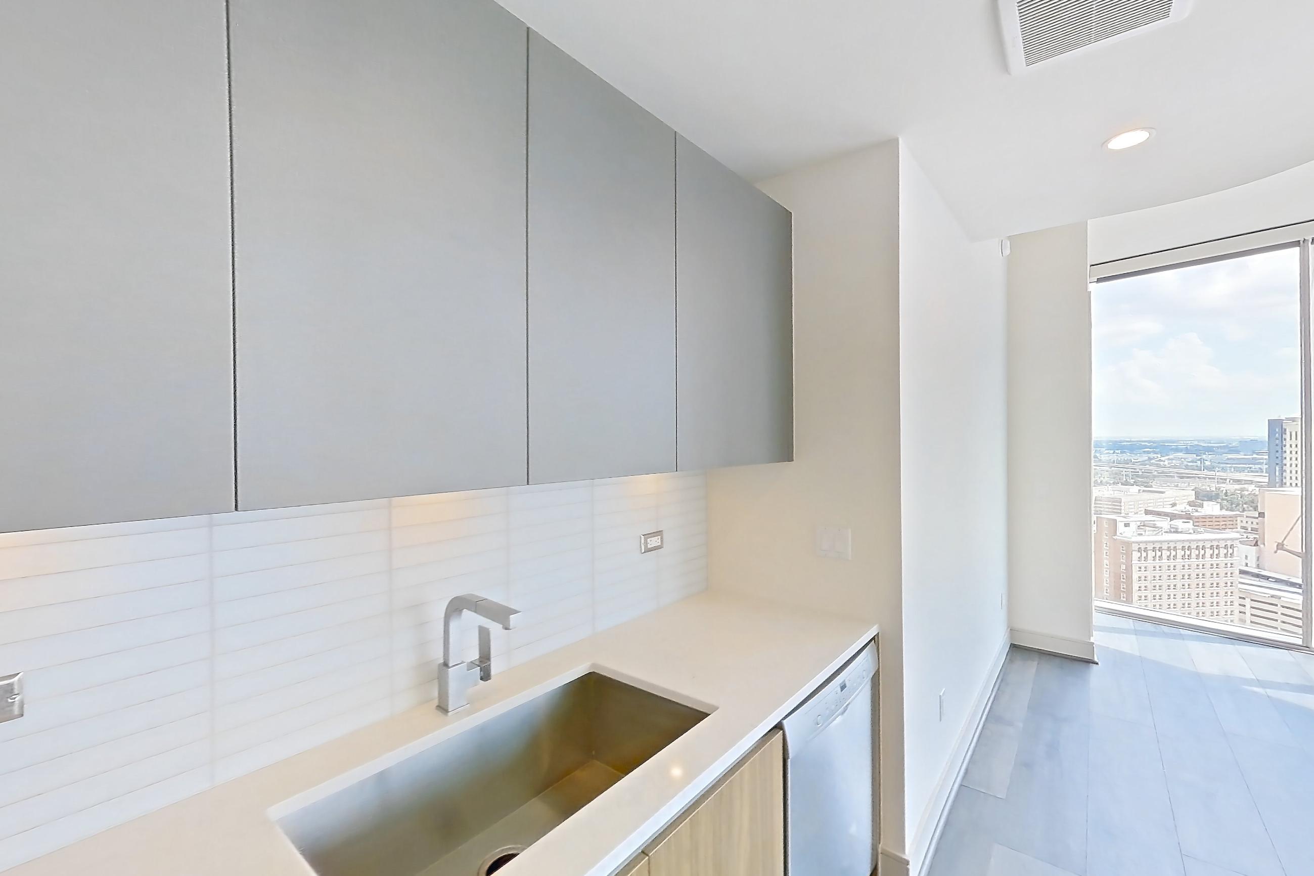 Kitchen with dark wood-finish flooring, gas range, light stone countertops, oven/range, and stainless steel appliances, Apartment 2803 at Brava