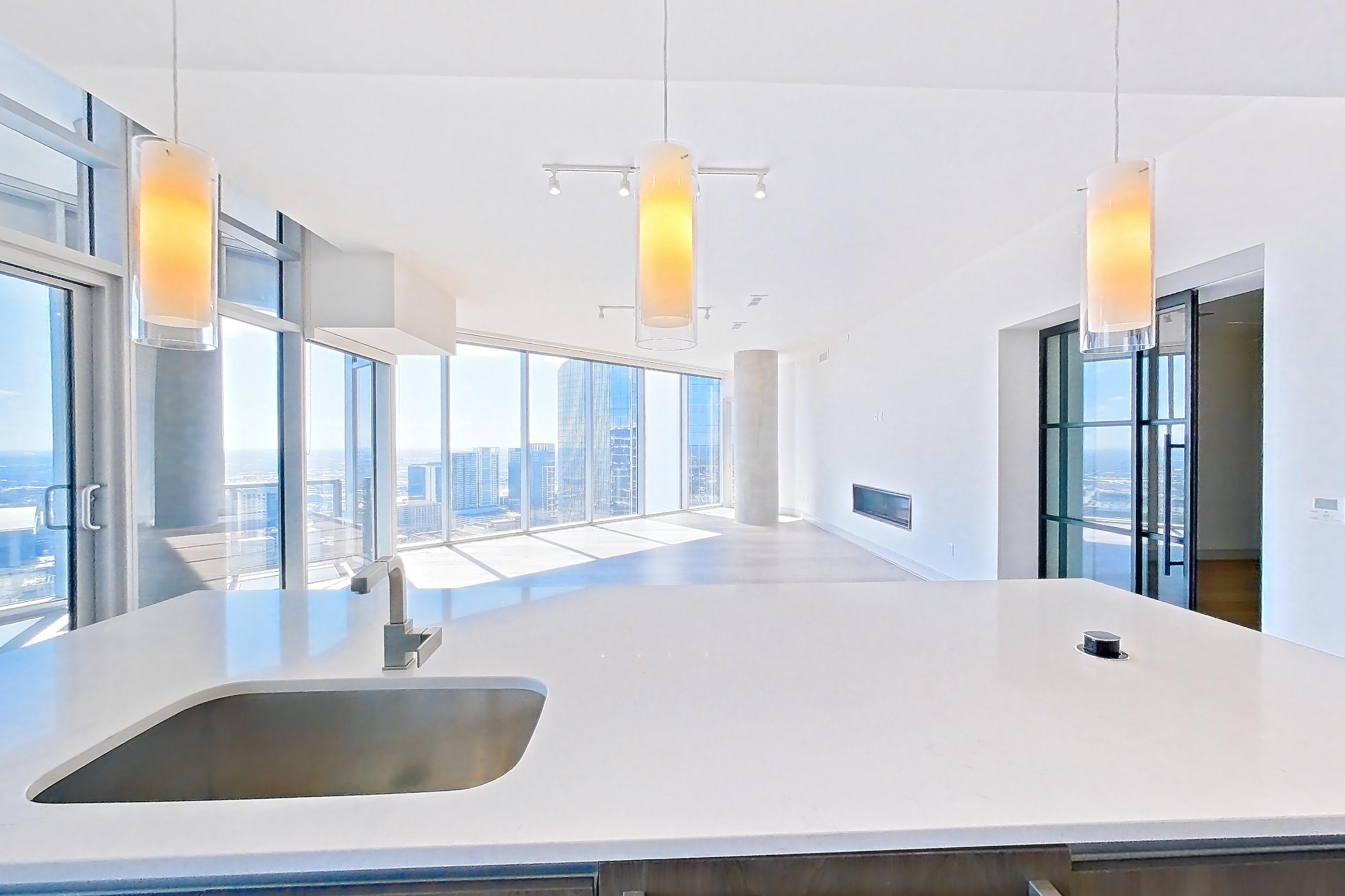 Kitchen with city view, cooktop, double oven, gas cooktop, light stone countertops, light wood-finish flooring, stainless steel appliances, and wood-finish flooring, Apartment 4602 at Brava