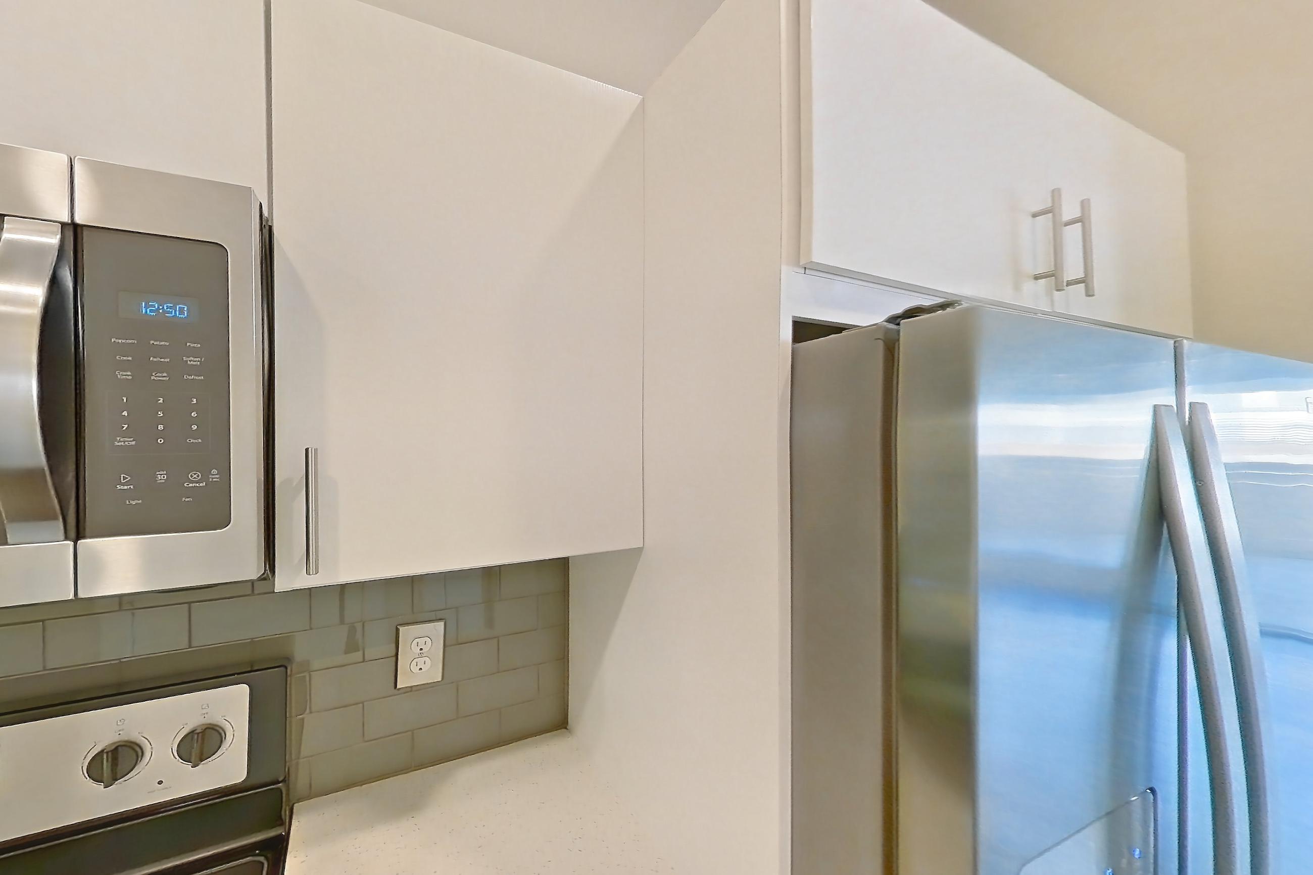 Kitchen with dark wood-finish flooring, electric range, light countertops, microwave, oven/range, and stainless steel appliances, Unit 279 at Harvest Lofts