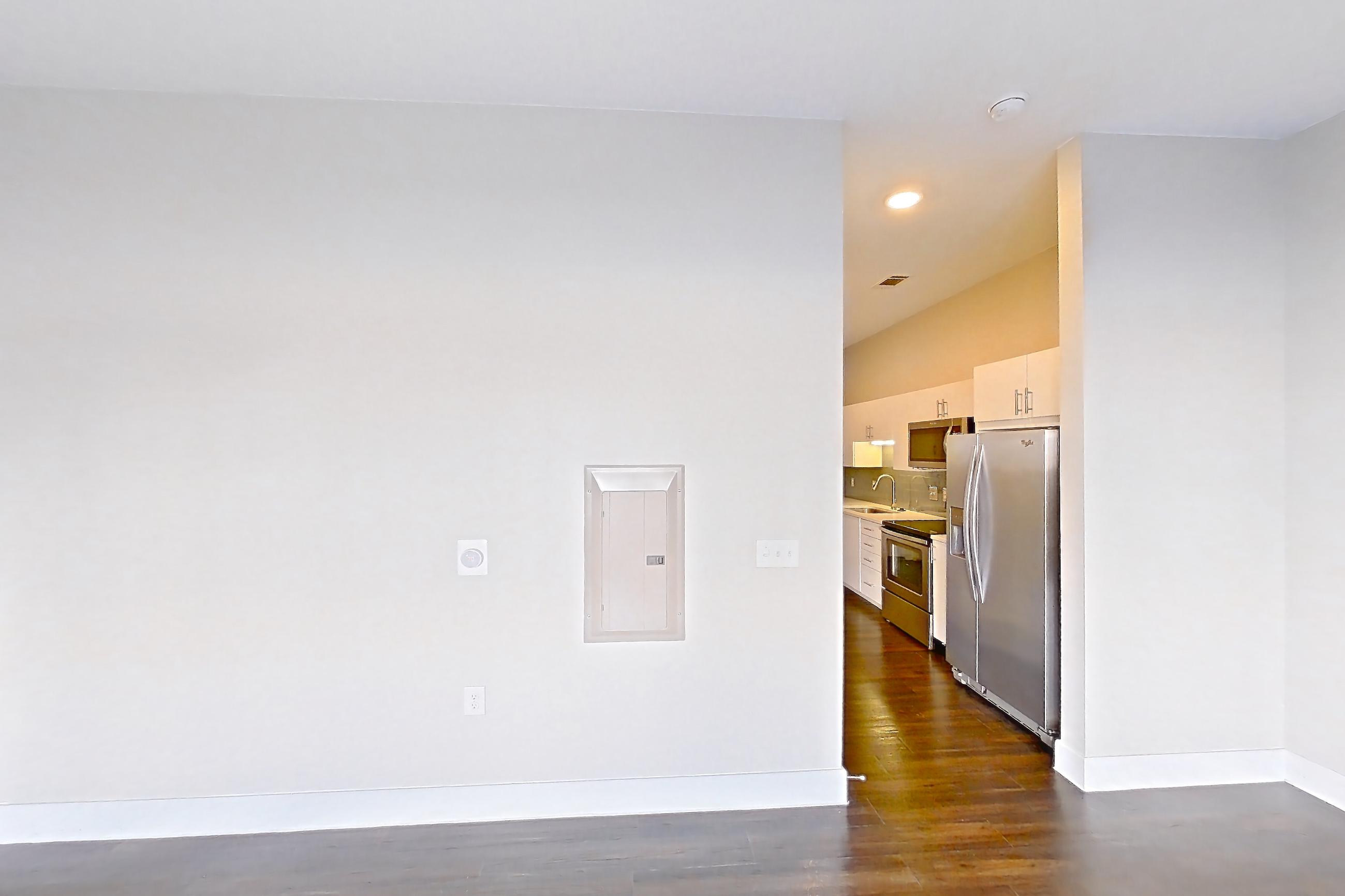 Living space with dark wood-finish flooring, electric range, oven/range, refrigerator, stainless steel appliances, water & ice dispenser, and white appliances, Unit 279 at Harvest Lofts